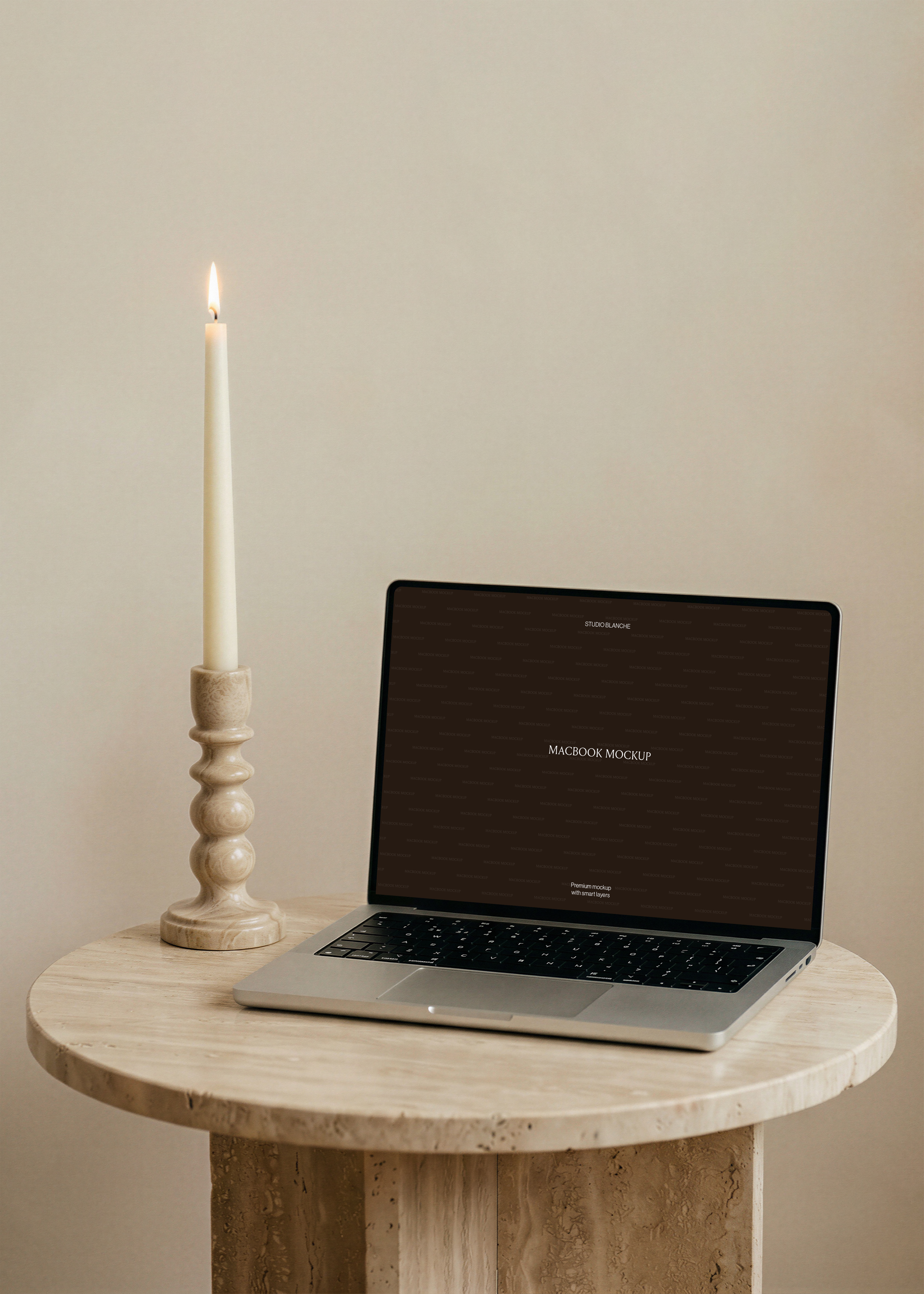 MacBook mockup detail of a silver laptop with dark widescreen and black keyboard on travertine stone, soft neutral light
