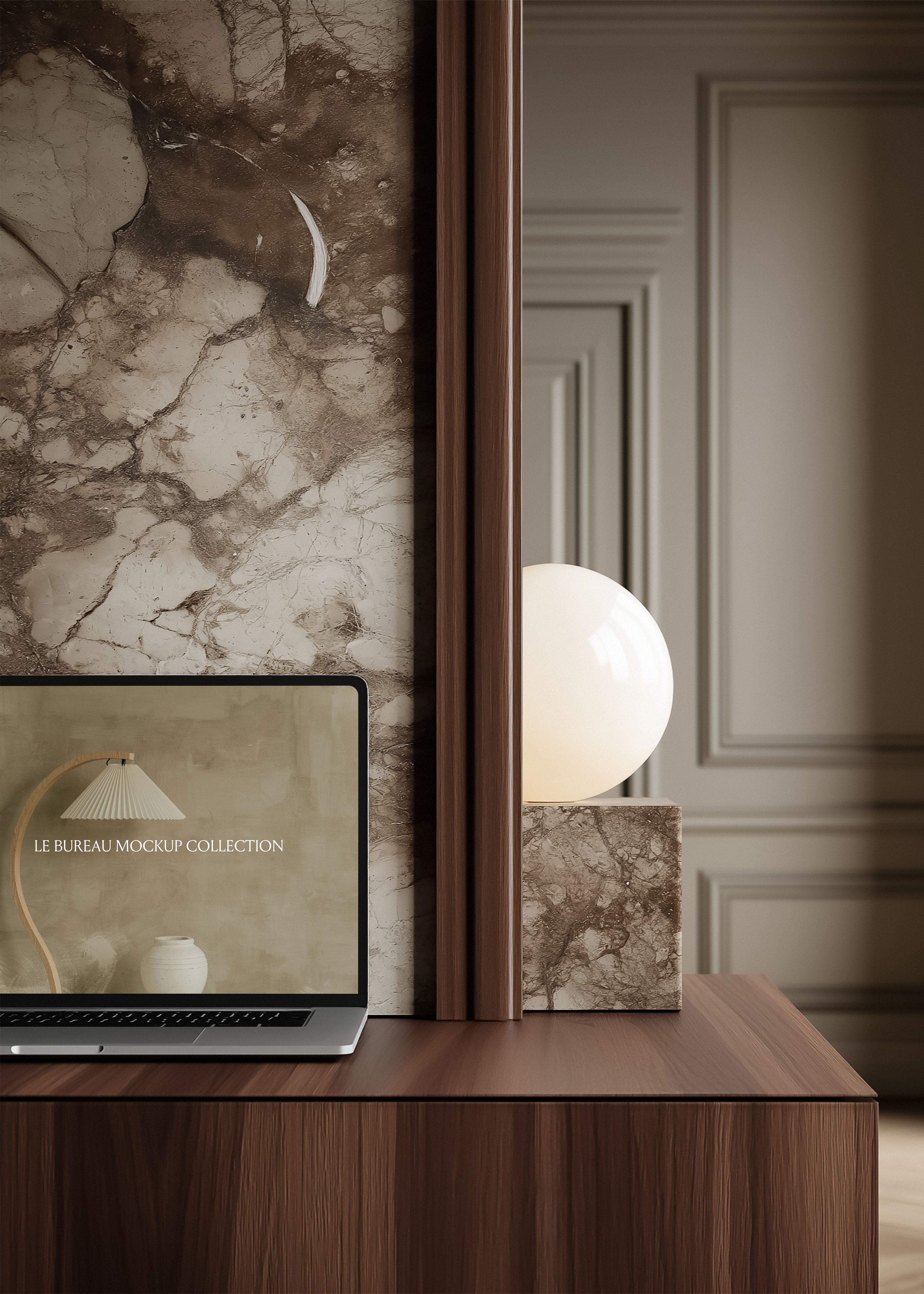 MacBook mockup displaying Le Bureau editorial on walnut desk, stone globe lamp and veined marble panel background