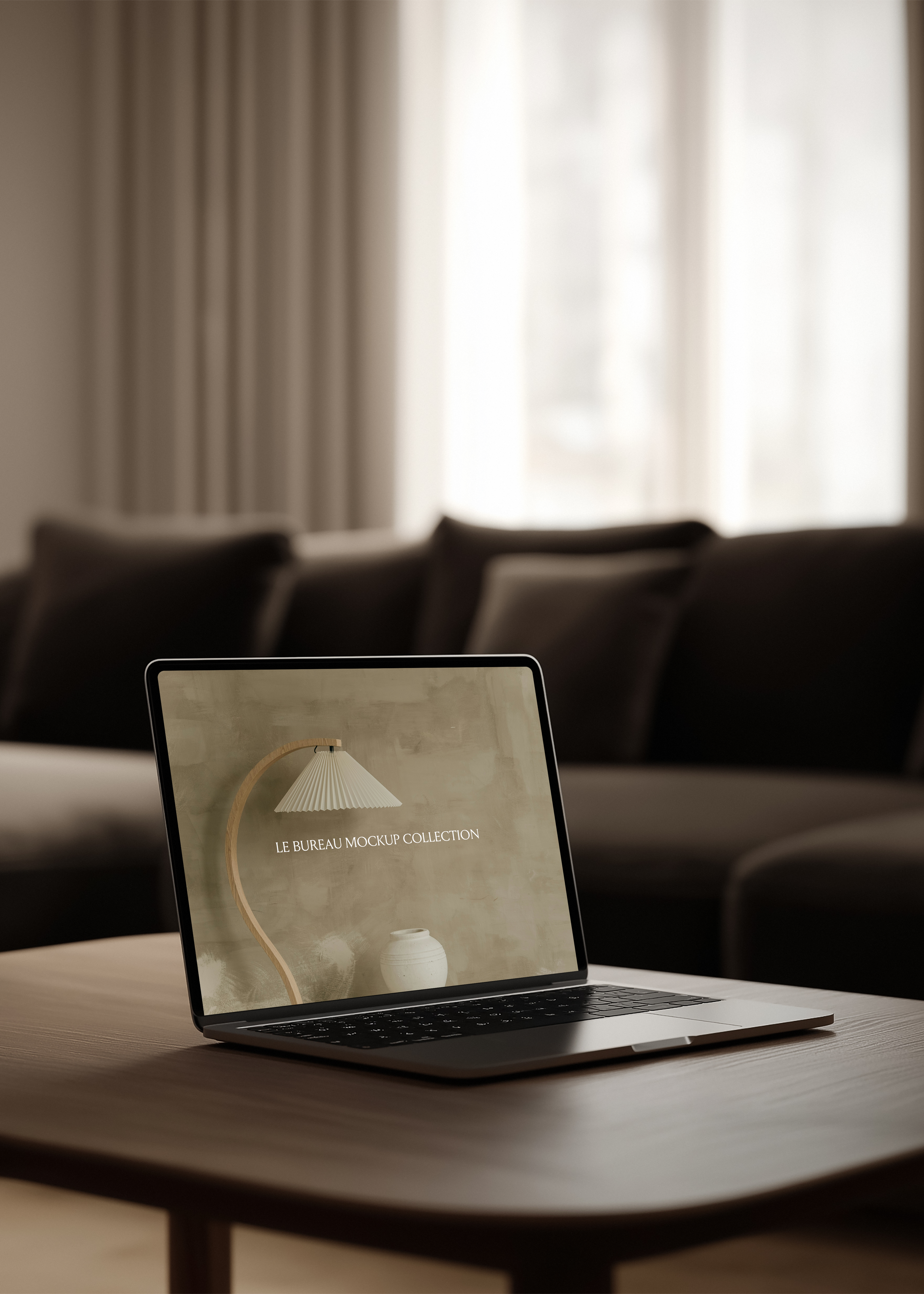 MacBook mockup displaying Le Bureau editorial on dark oak coffee table, blurred charcoal sofa and curtained window backdrop