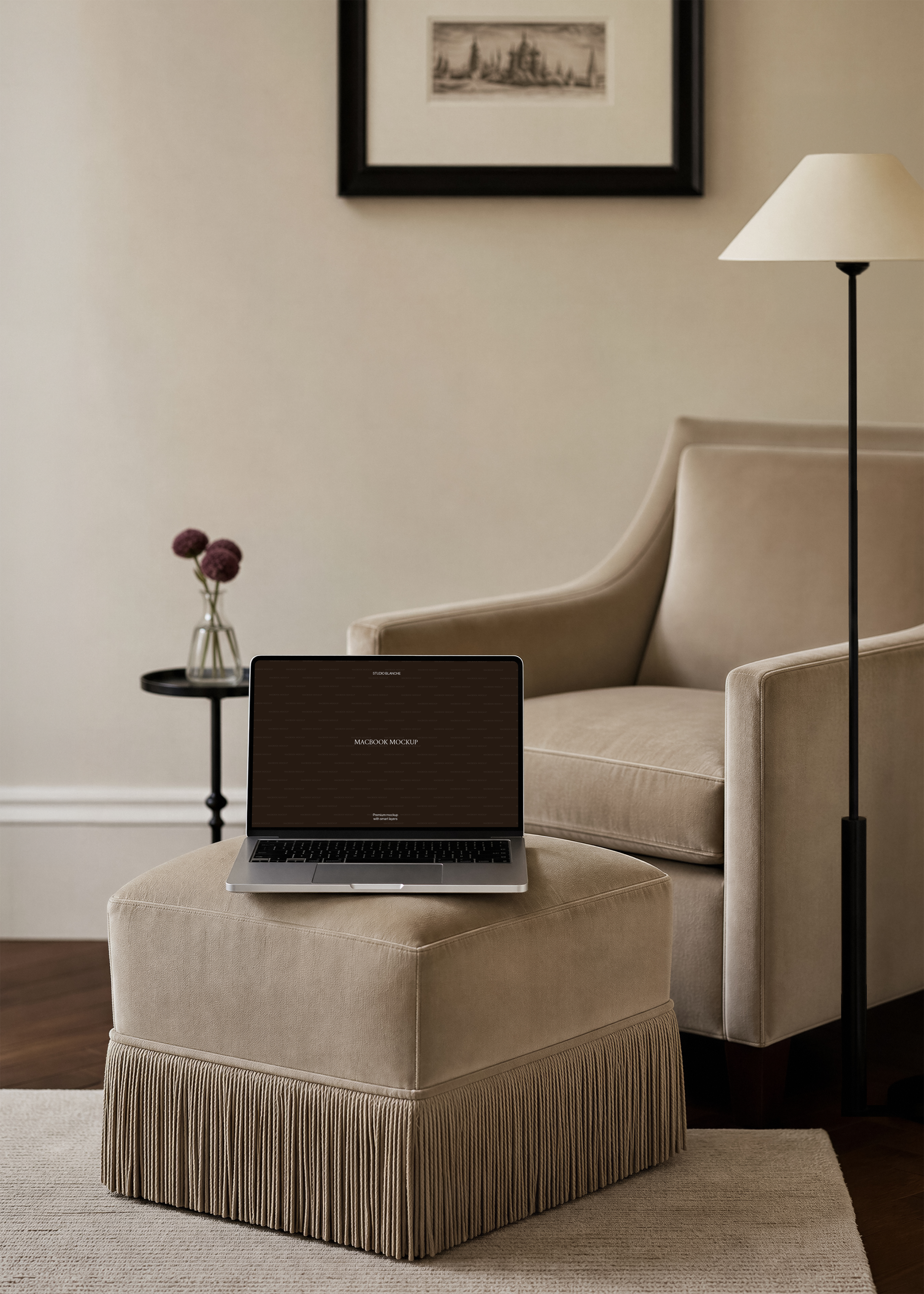 MacBook mockup detail of a dark laptop screen on fringed velvet, small black side table with flowers in a glass vase behind
