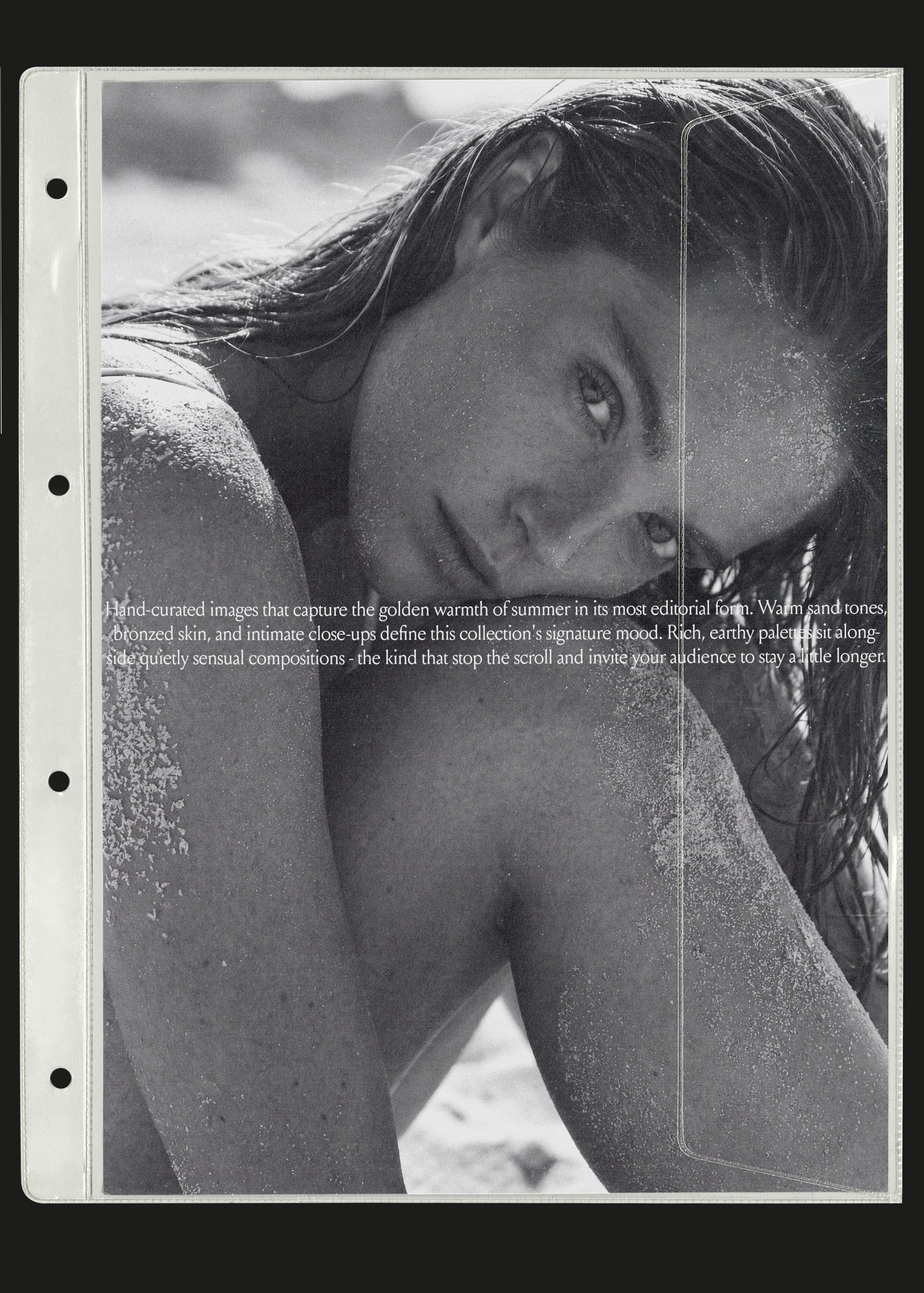 Black and white summer stock image of woman resting her head on her arm on the sand, editorial close-up beach portrait