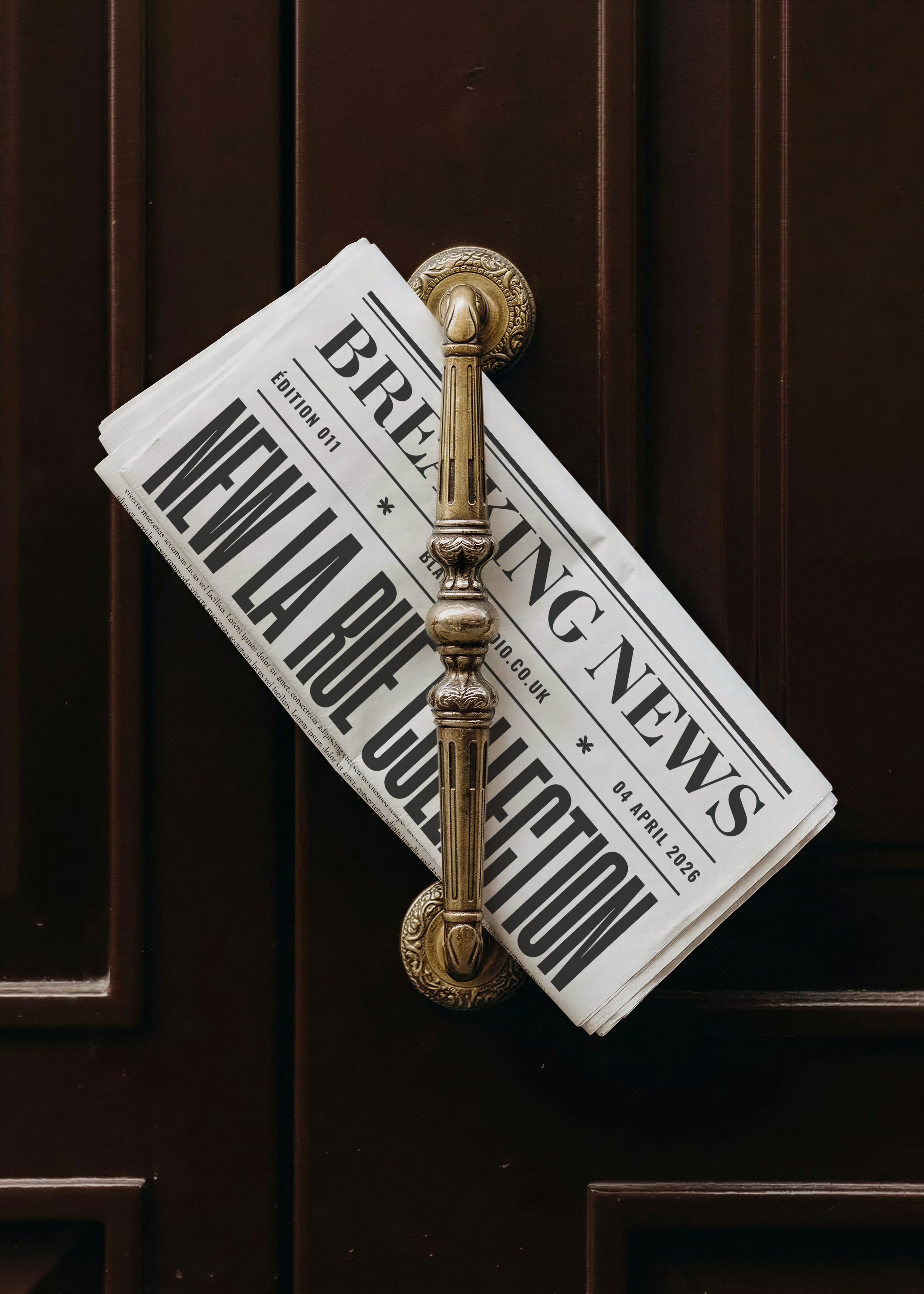 Folded newspaper mockup with bold breaking news front page headline displayed on ornate brass door handle against dark wood door, from Studio Blanche