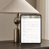 Notion client portal Creative Direction page on an iPad, showing brand messaging, core values and target audience sections beside a brass table lamp.