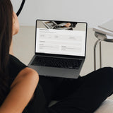 Woman viewing the Notion client portal Contracts & Payments page on a laptop, showing payments made, amount paid, next payment due and project documents.
