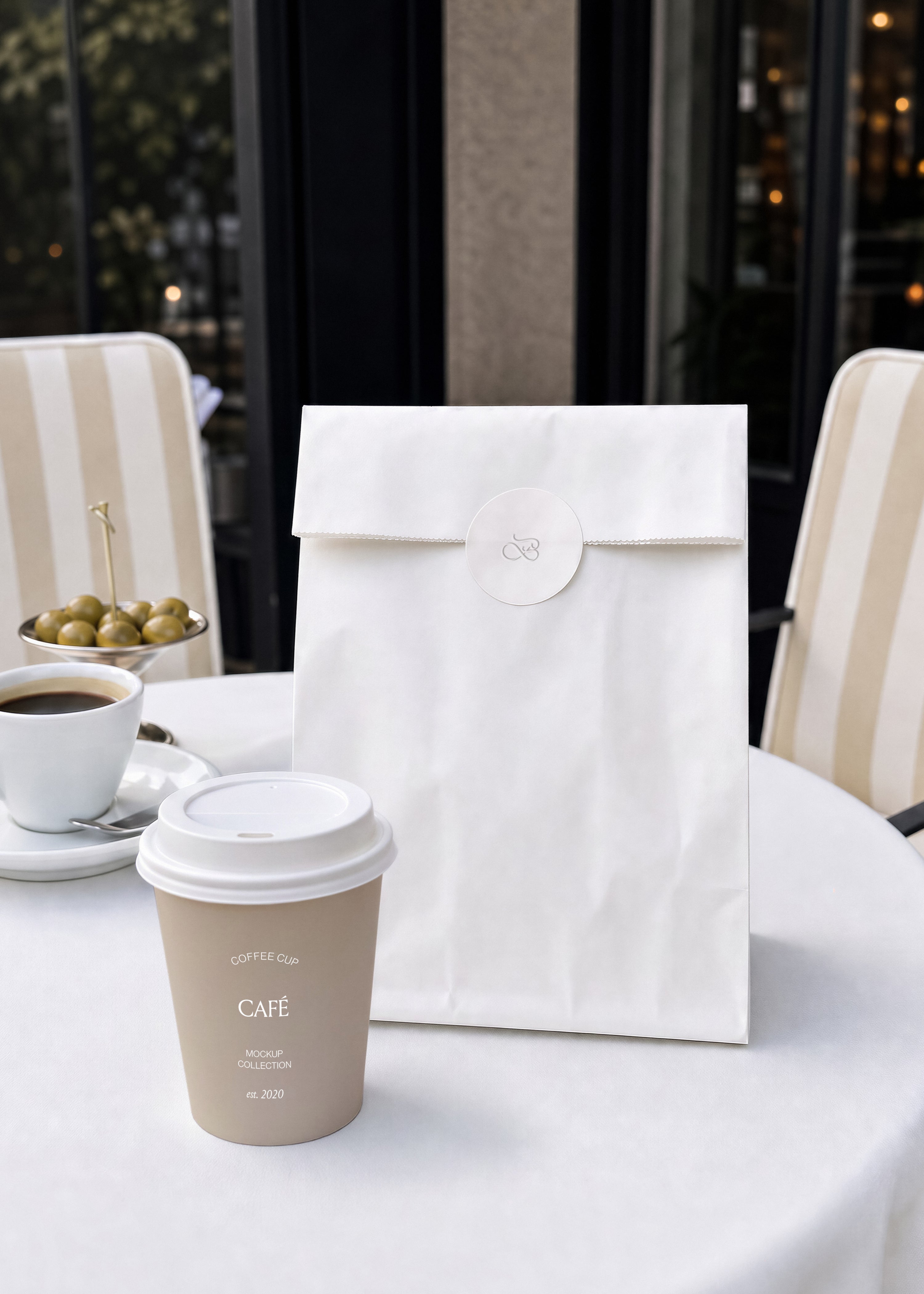 Coffee cup and paper bag mockup, beige cup with white lid beside sticker-sealed bag on café table with striped chairs