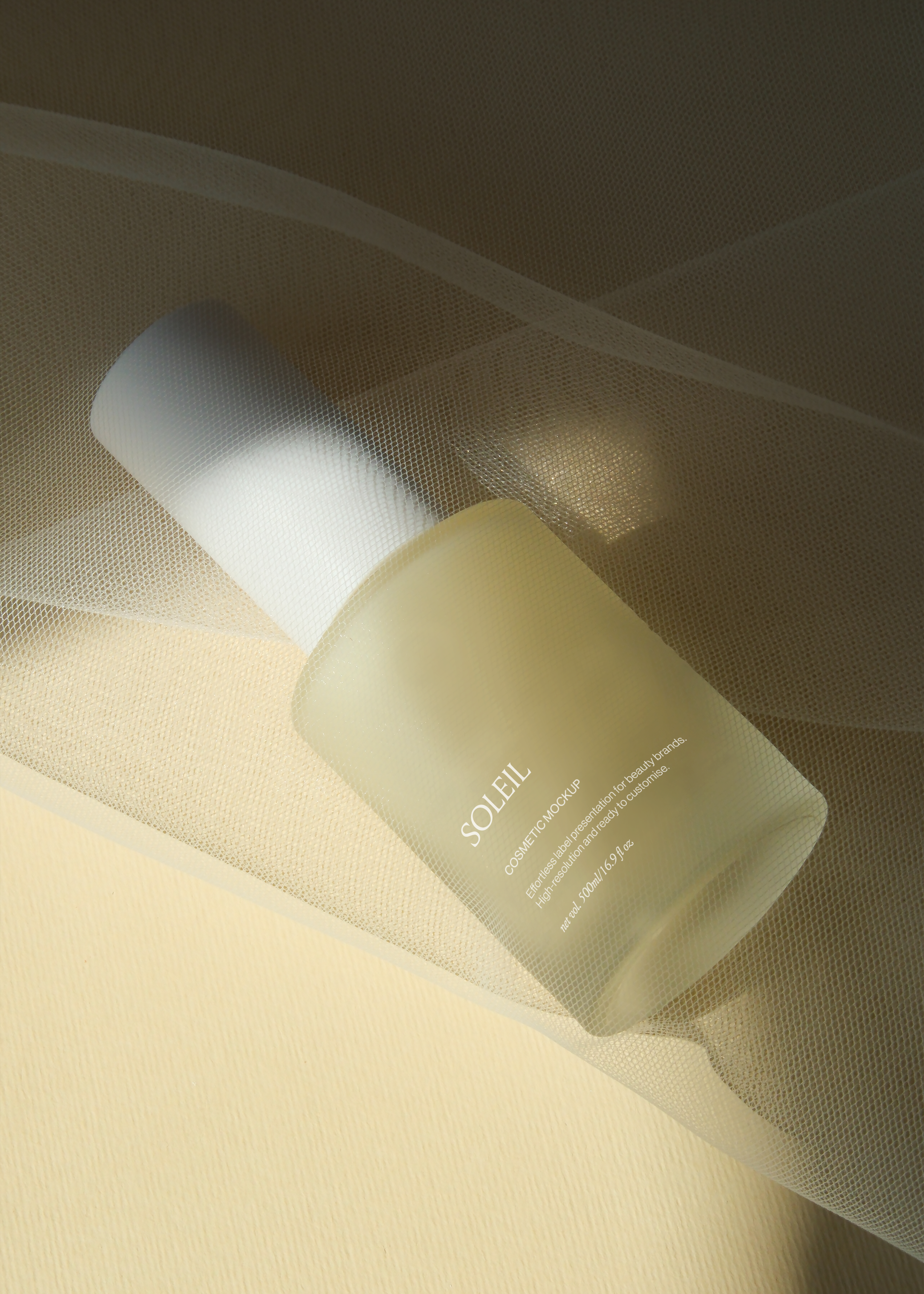 Frosted glass pump bottle mockup veiled beneath sheer tulle fabric, warm candlelit tones, soft romantic styling