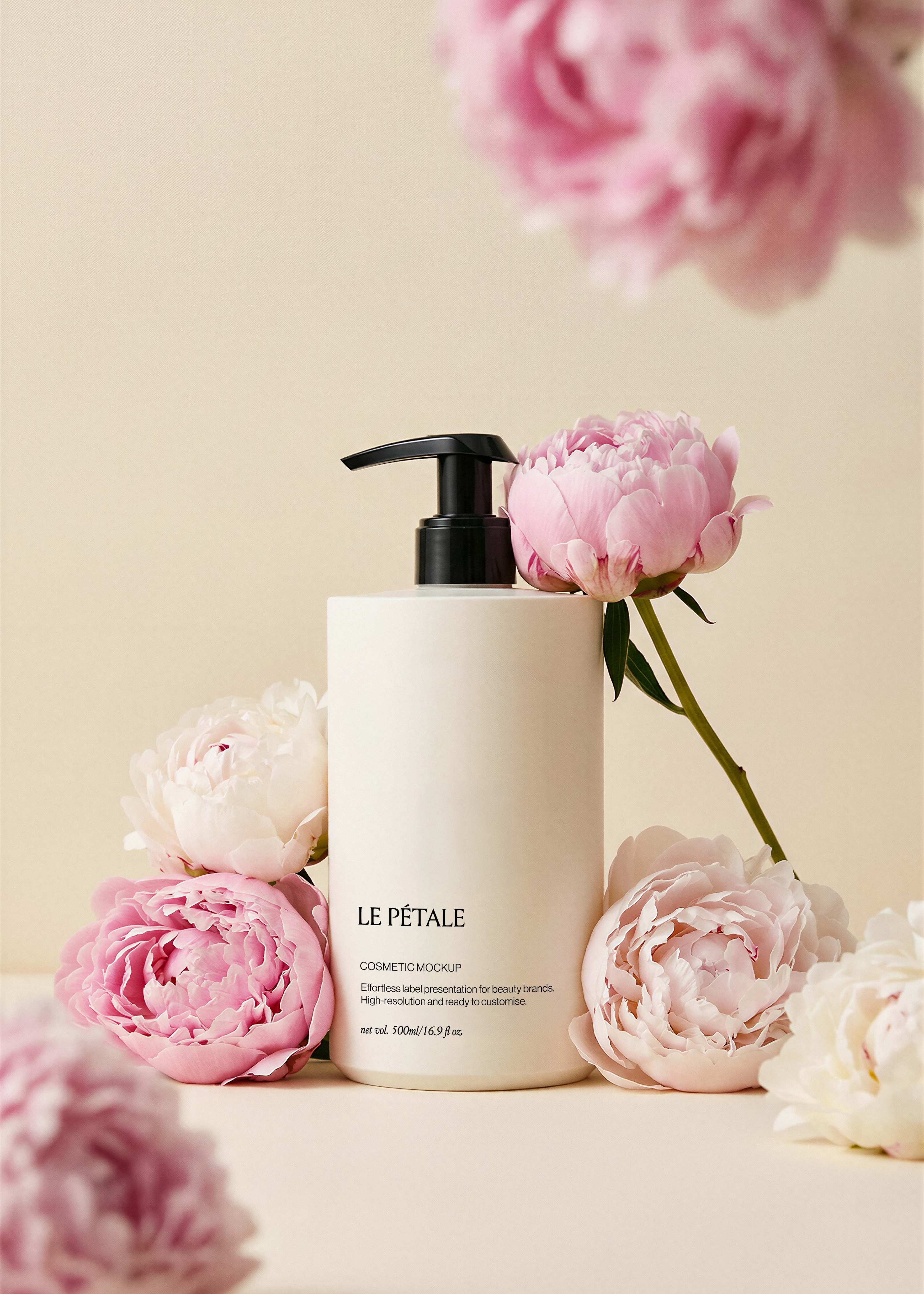 Pump bottle mockup with label, pink and blush peonies surrounding base, blurred peony overhead, warm sand backdrop
