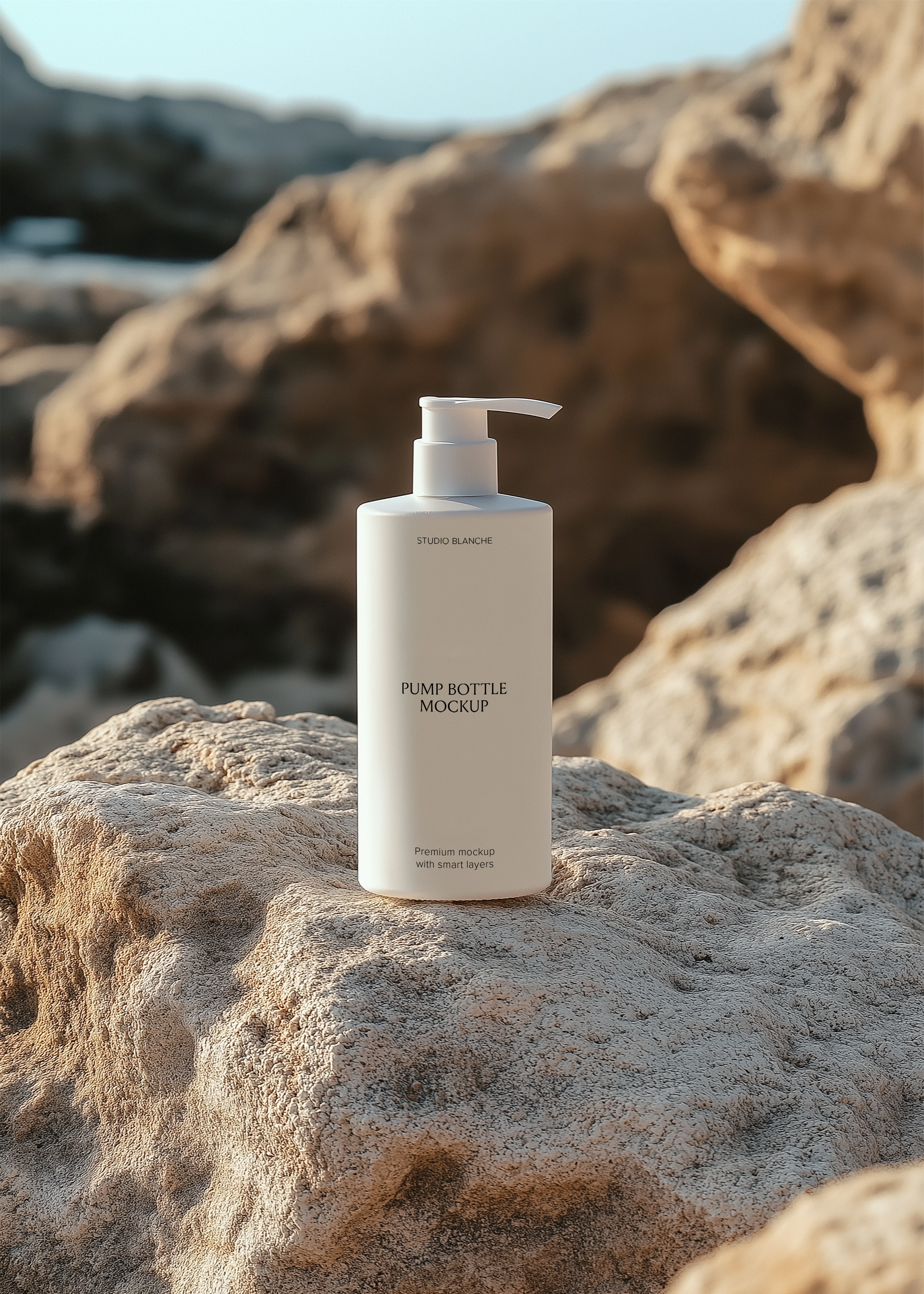 White pump bottle mockup with label on textured coastal rock surface, large warm boulders and blue sky blurred behind