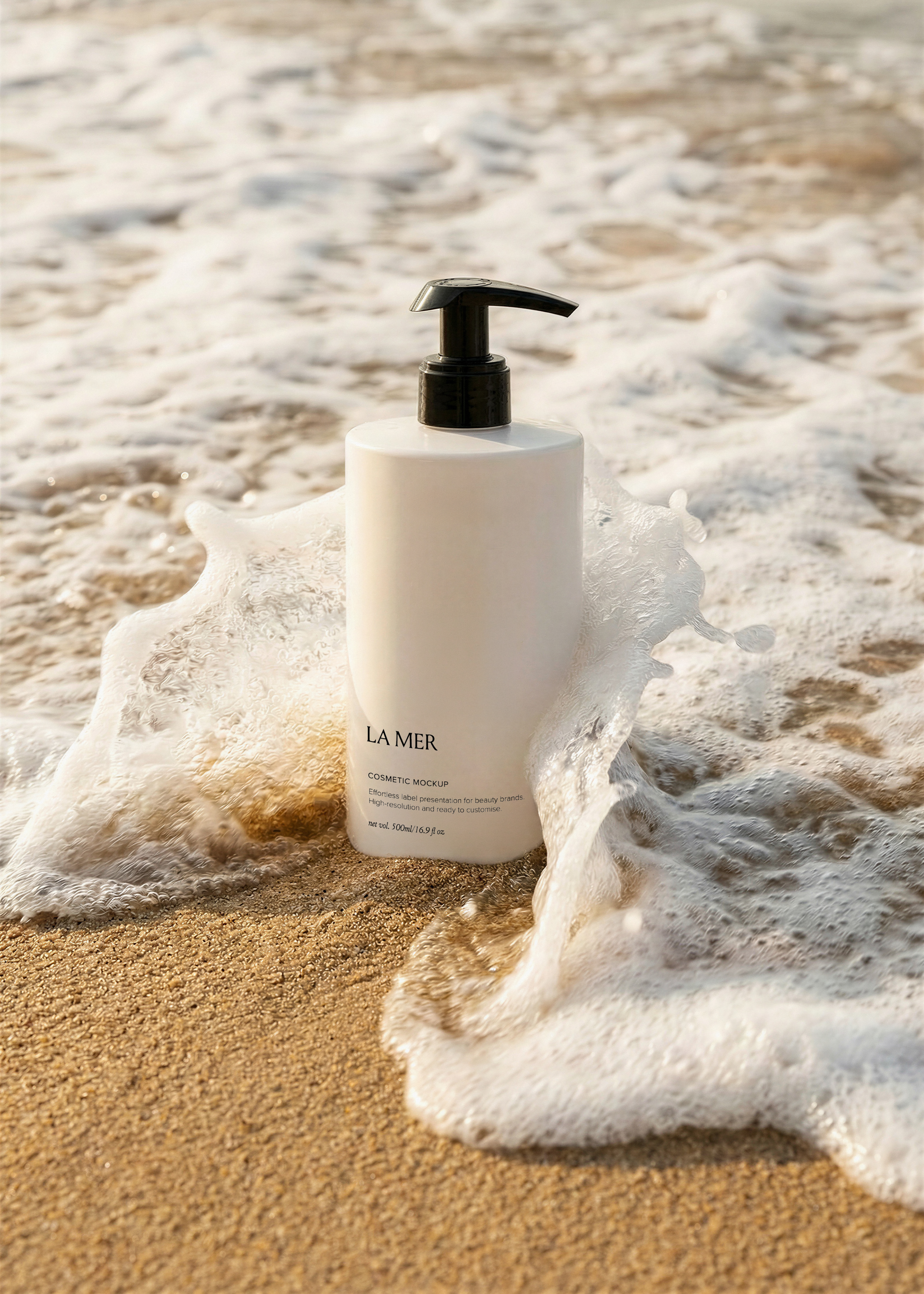 White pump bottle with branded cosmetic label standing in shallow foamy ocean waves on a sun-lit sandy beach, from Studio Blanche