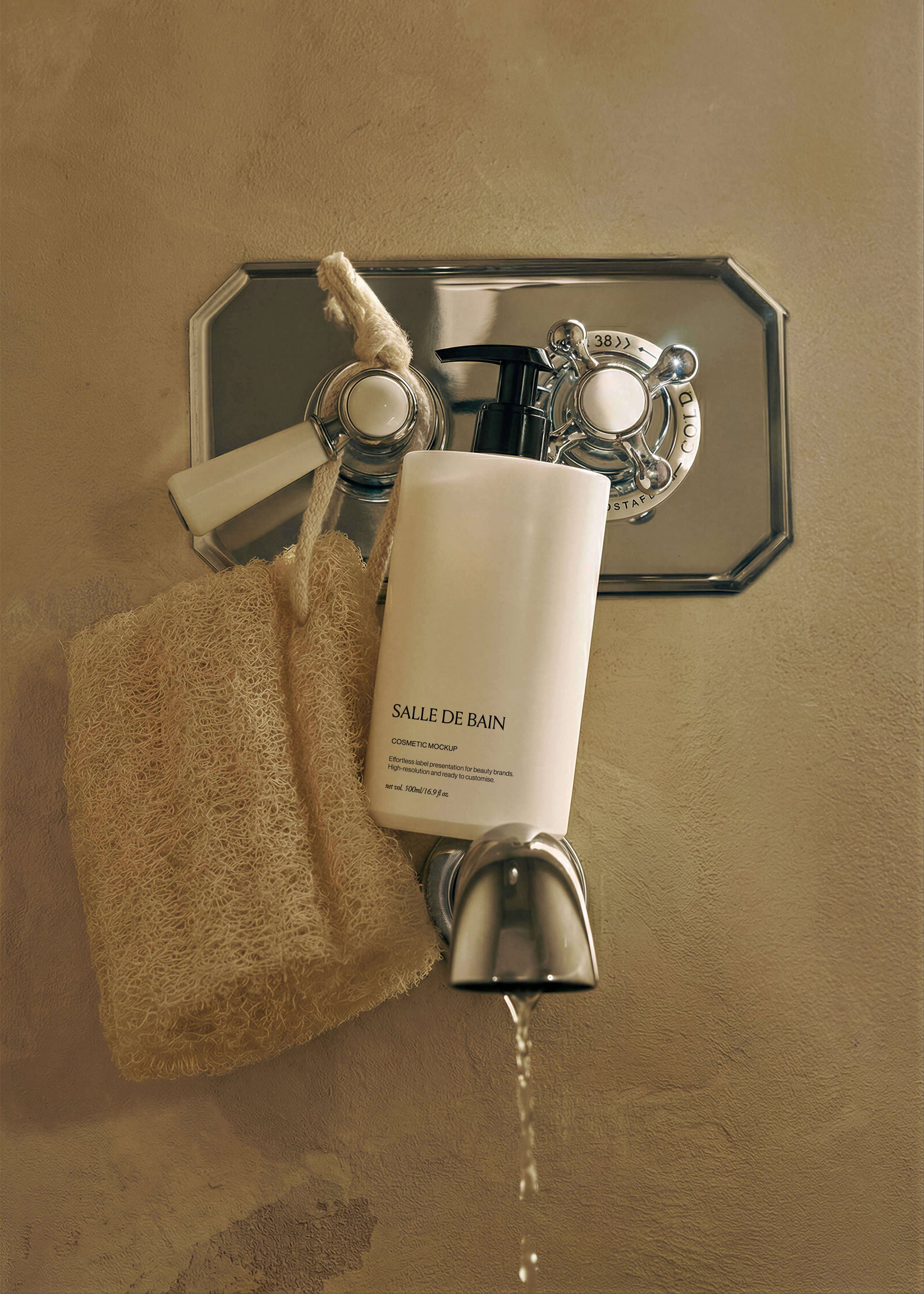 White cosmetic pump bottle propped against a chrome vintage tap on a warm ochre plaster wall beside a rope loofah
