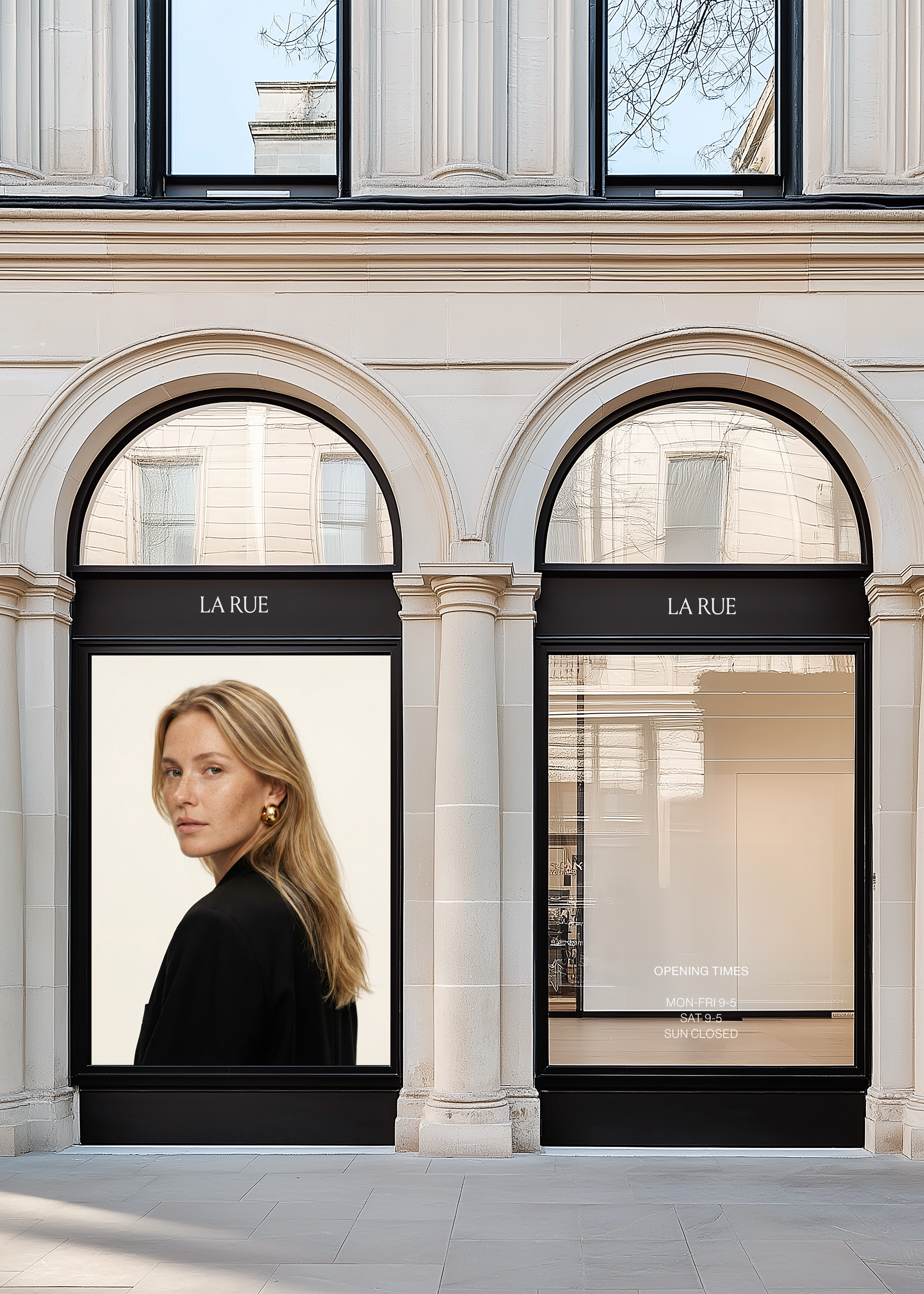 Shopfront mockup of a stone building with two black arched windows displaying editorial campaign artwork