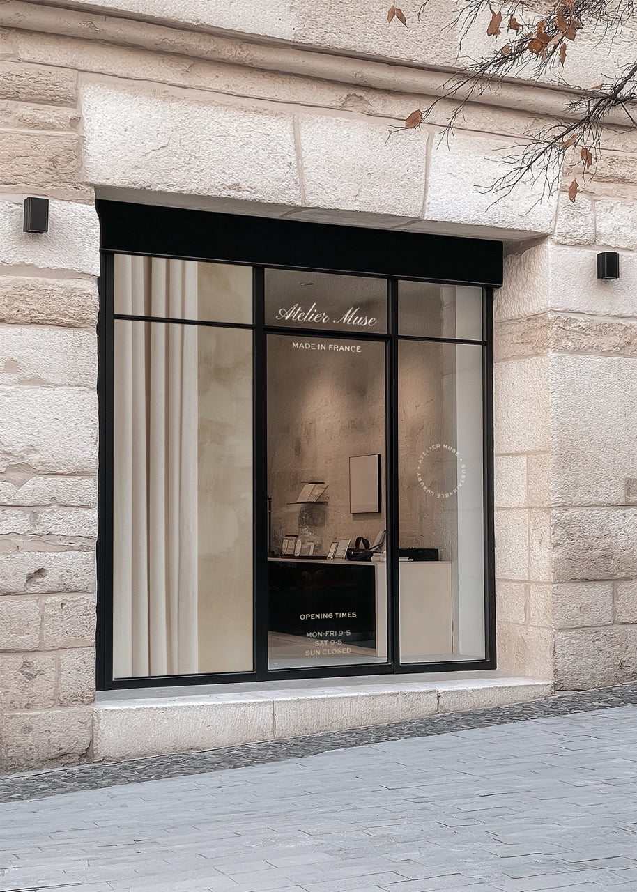 Storefront mockup PSD with large glass window displaying interior, stone building exterior