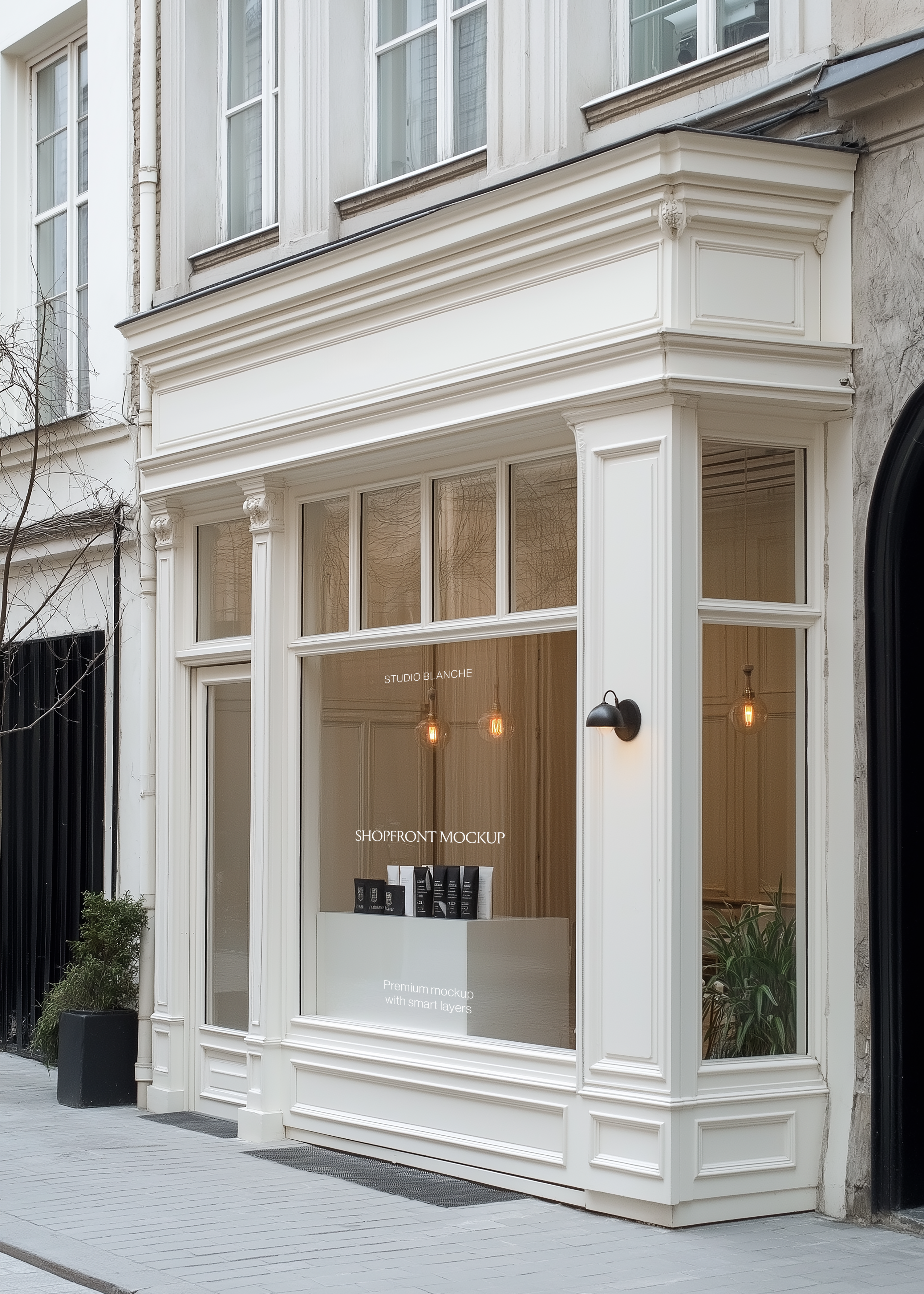 Corner salon storefront mockup with moulded cream facade, warm pendant lighting, potted plants and grey paving