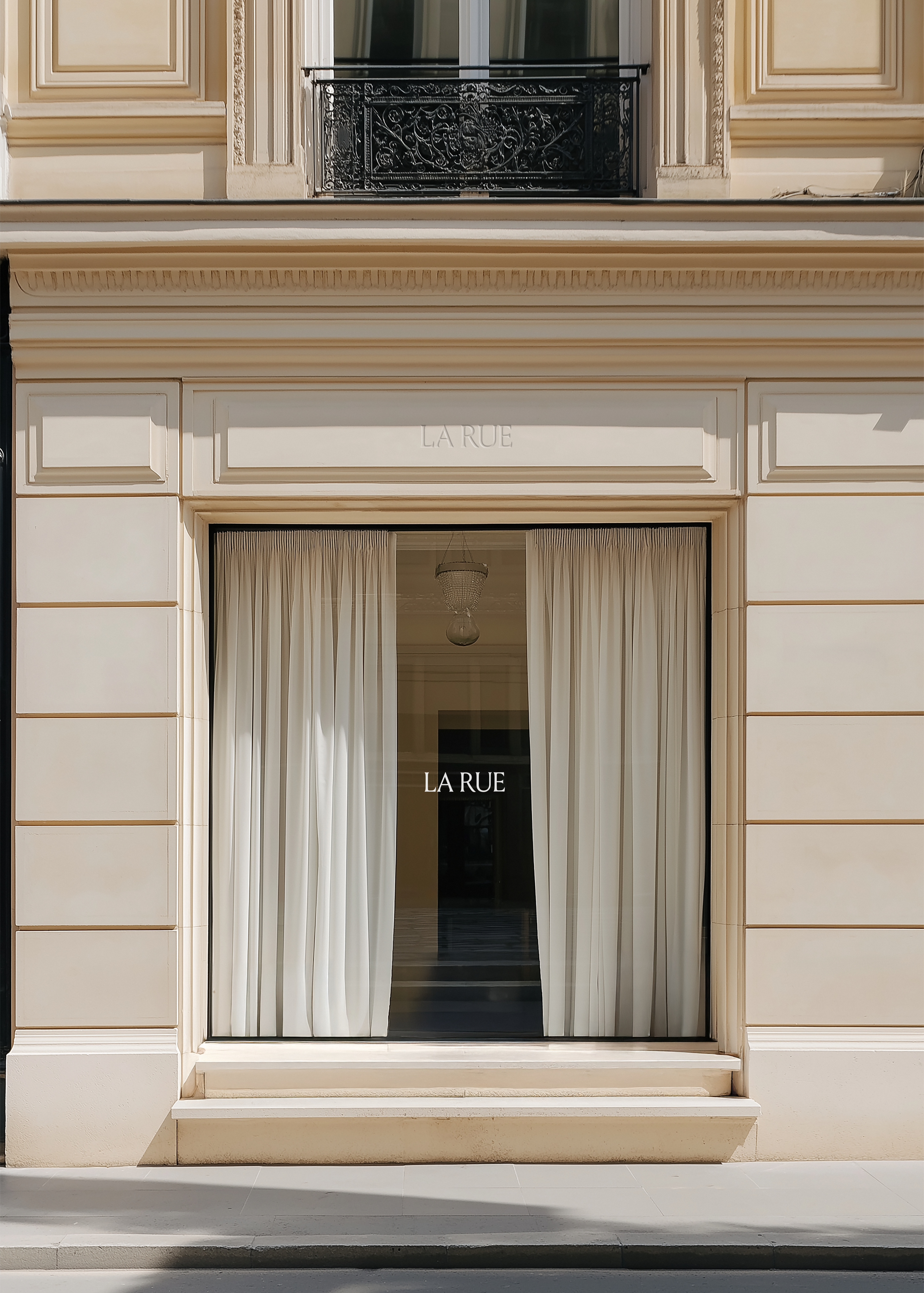 Shopfront mockup of a sunlit sandstone facade with LA RUE window signage, sheer curtains and chandelier behind glass