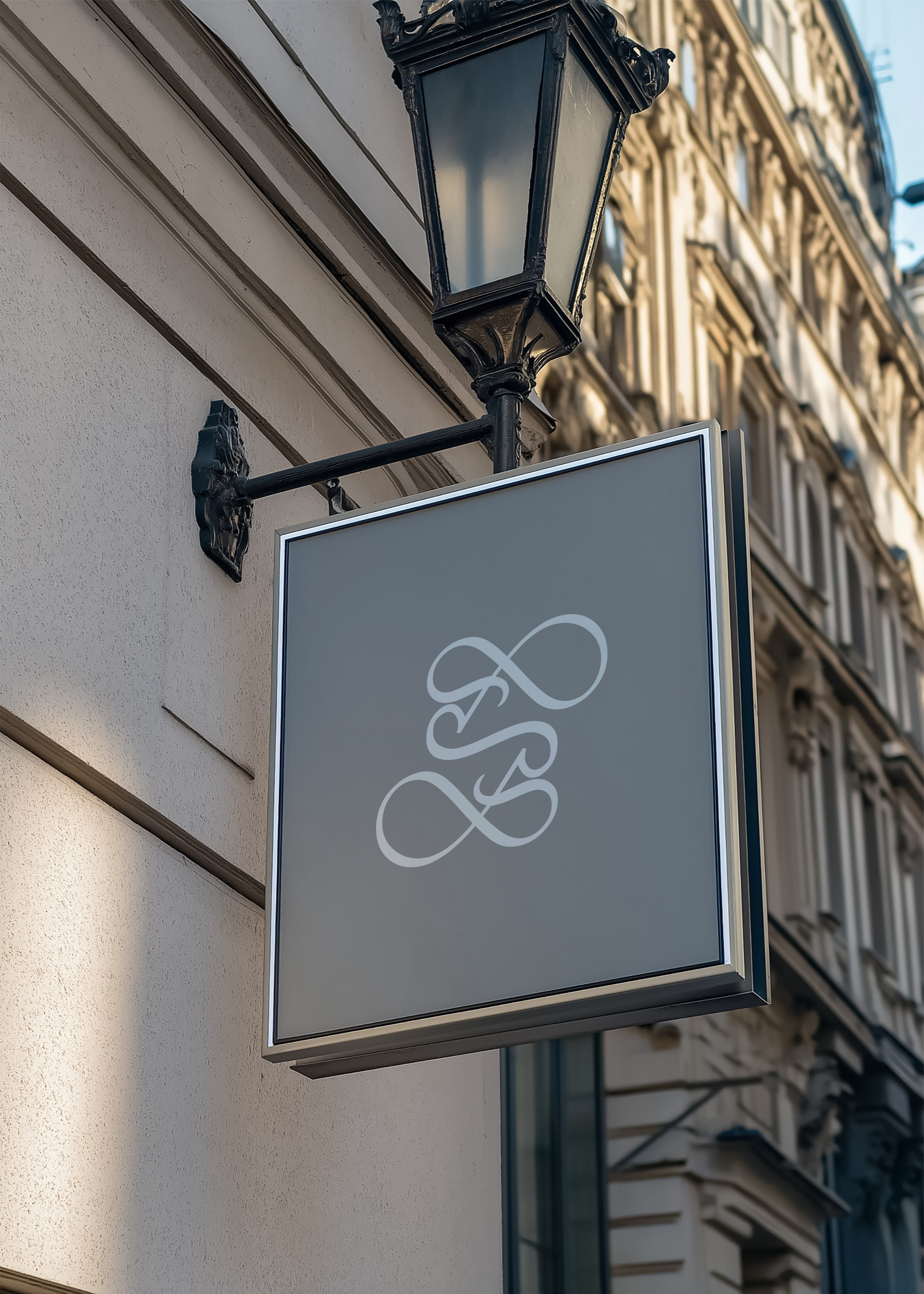 Hanging sign mockup displaying logo brand identity on white panel, ornate lamp post and Parisian architecture behind