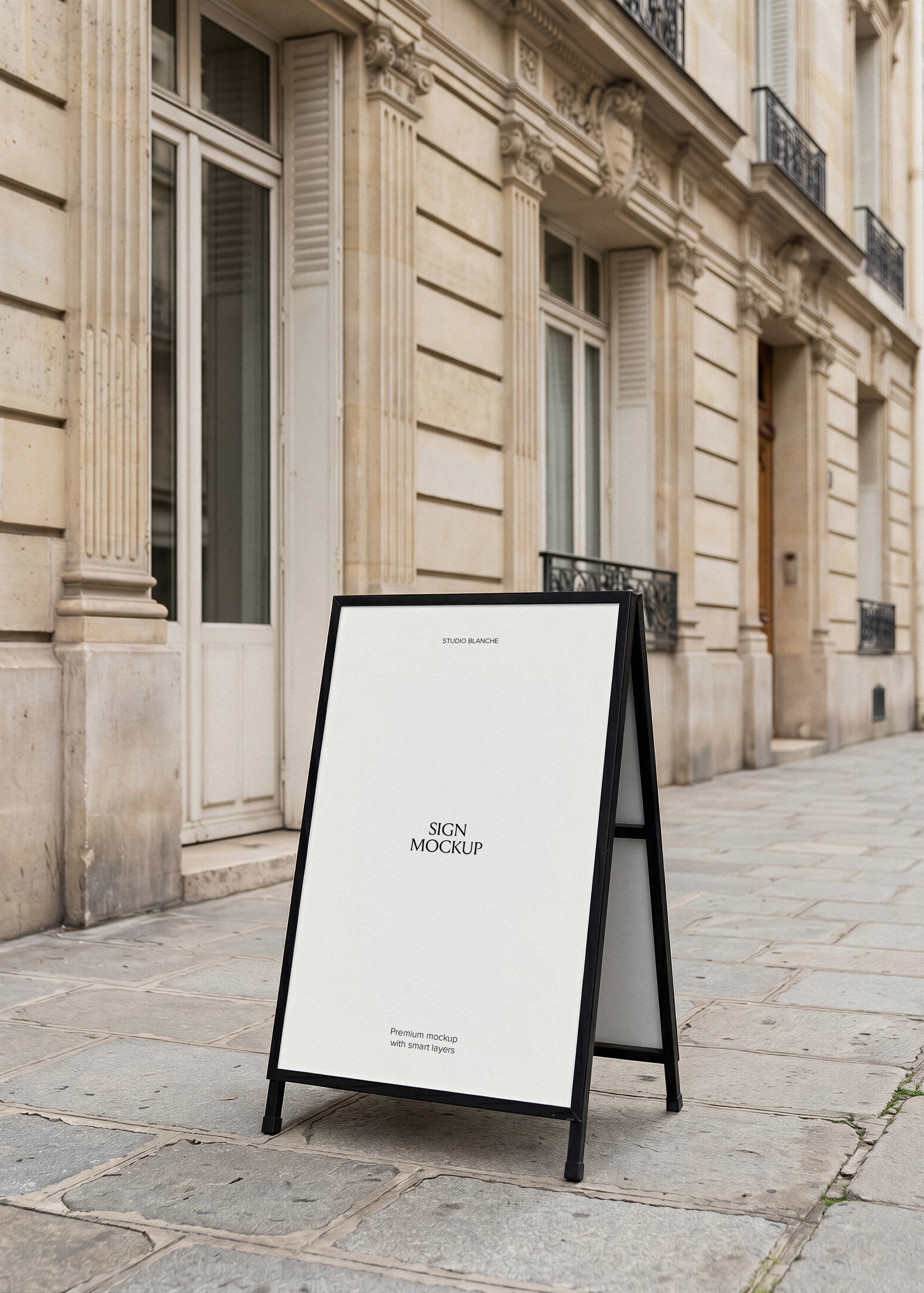 A-frame sign mockup styled on Parisian pavement, black metal frame, dark branded panel with white serif type, stone building