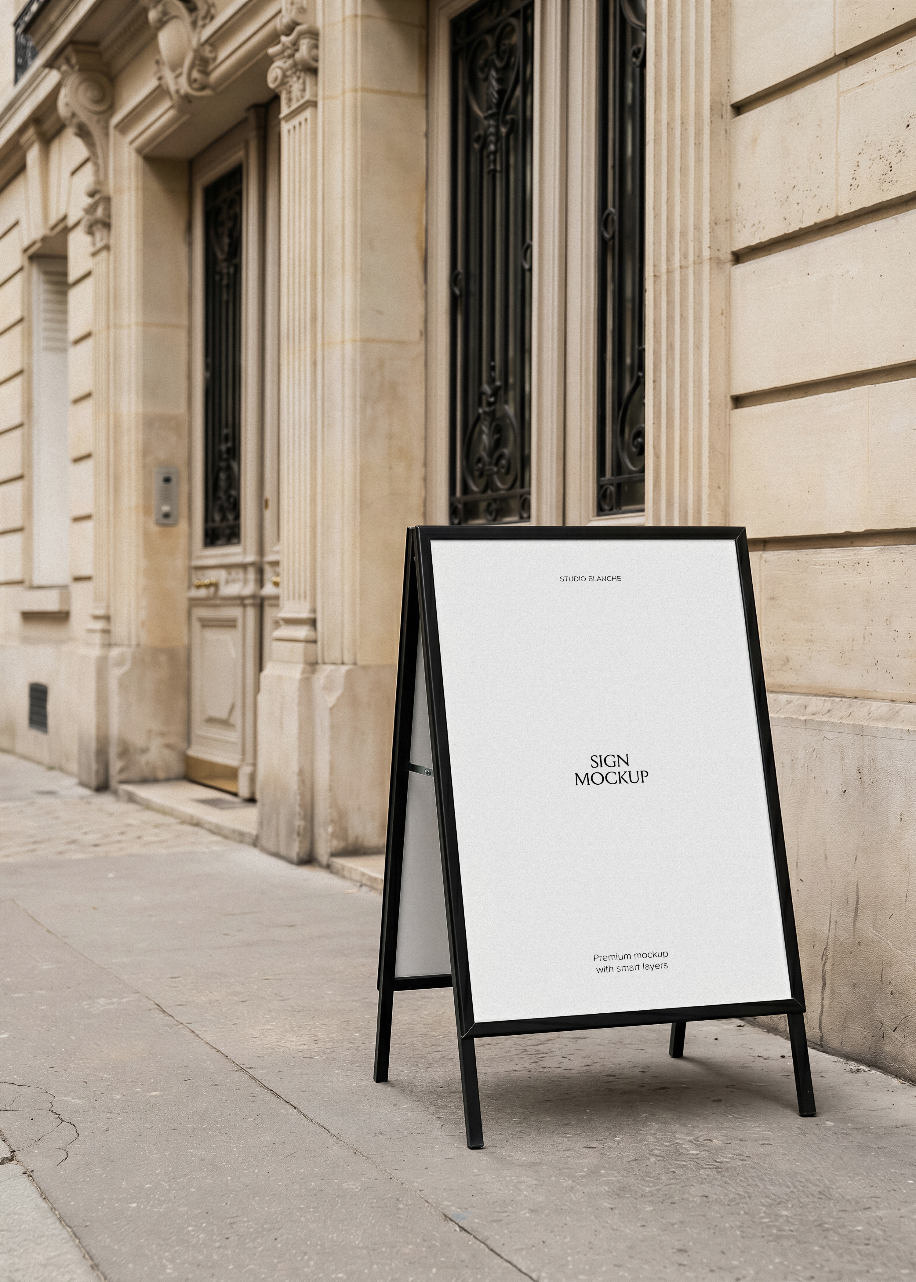 A-frame sign mockup beside Haussmann building, black frame, white insert, cobbled pavement, natural daylight, minimal styling