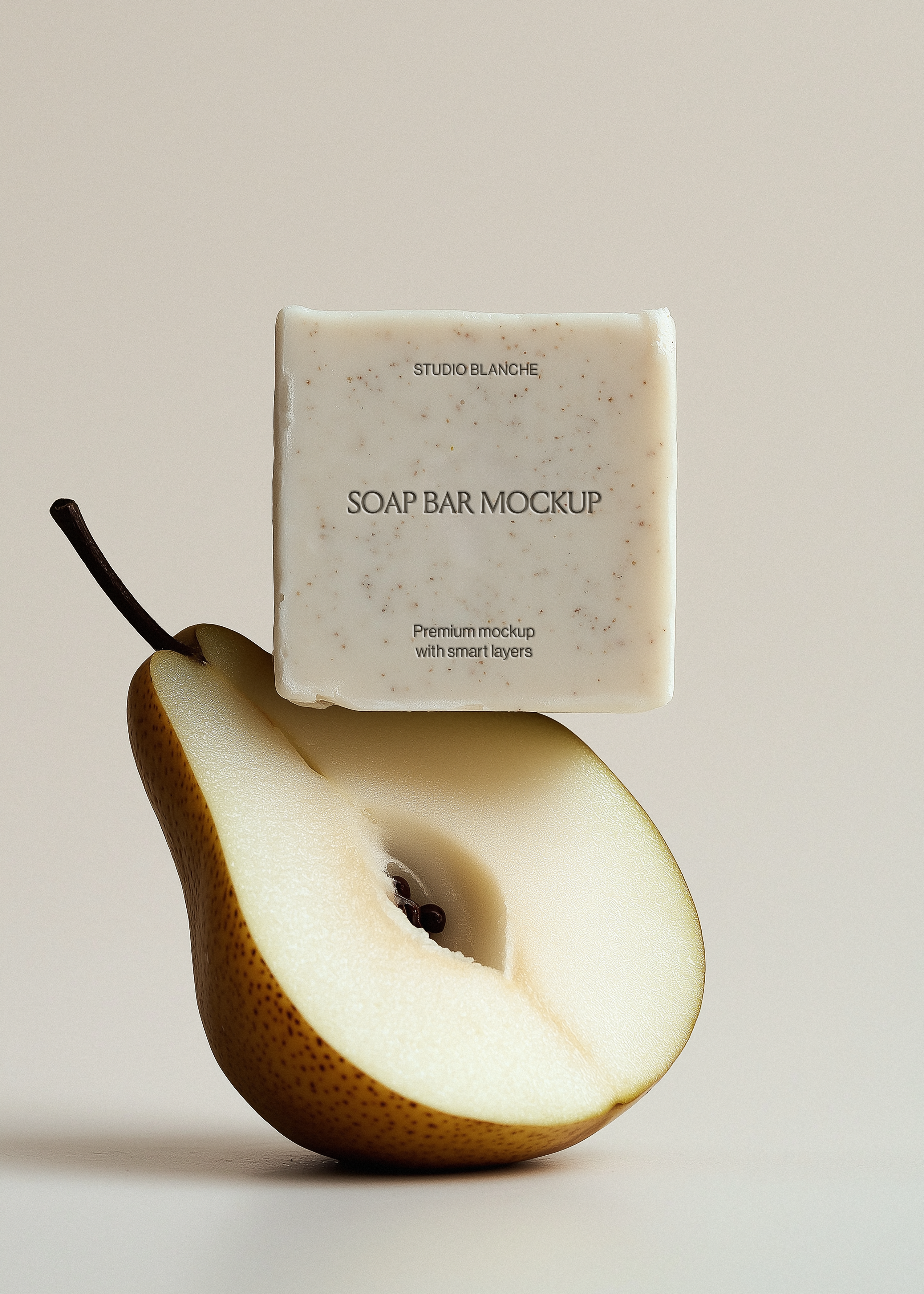 Textured speckled soap bar mockup on sliced pear, Studio Blanche label placeholder, warm grey backdrop