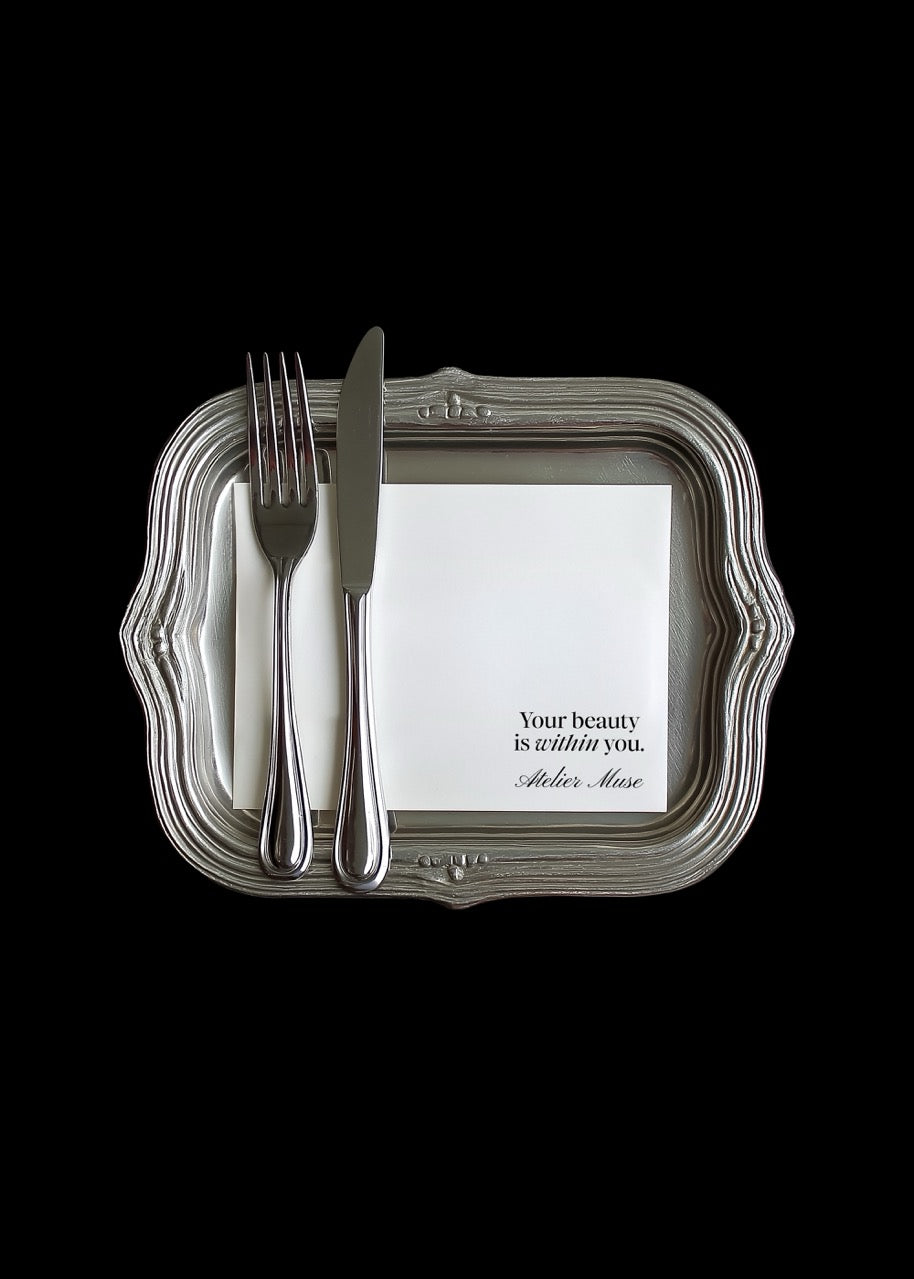 Decorative tray with fork, knife, and card on a black background