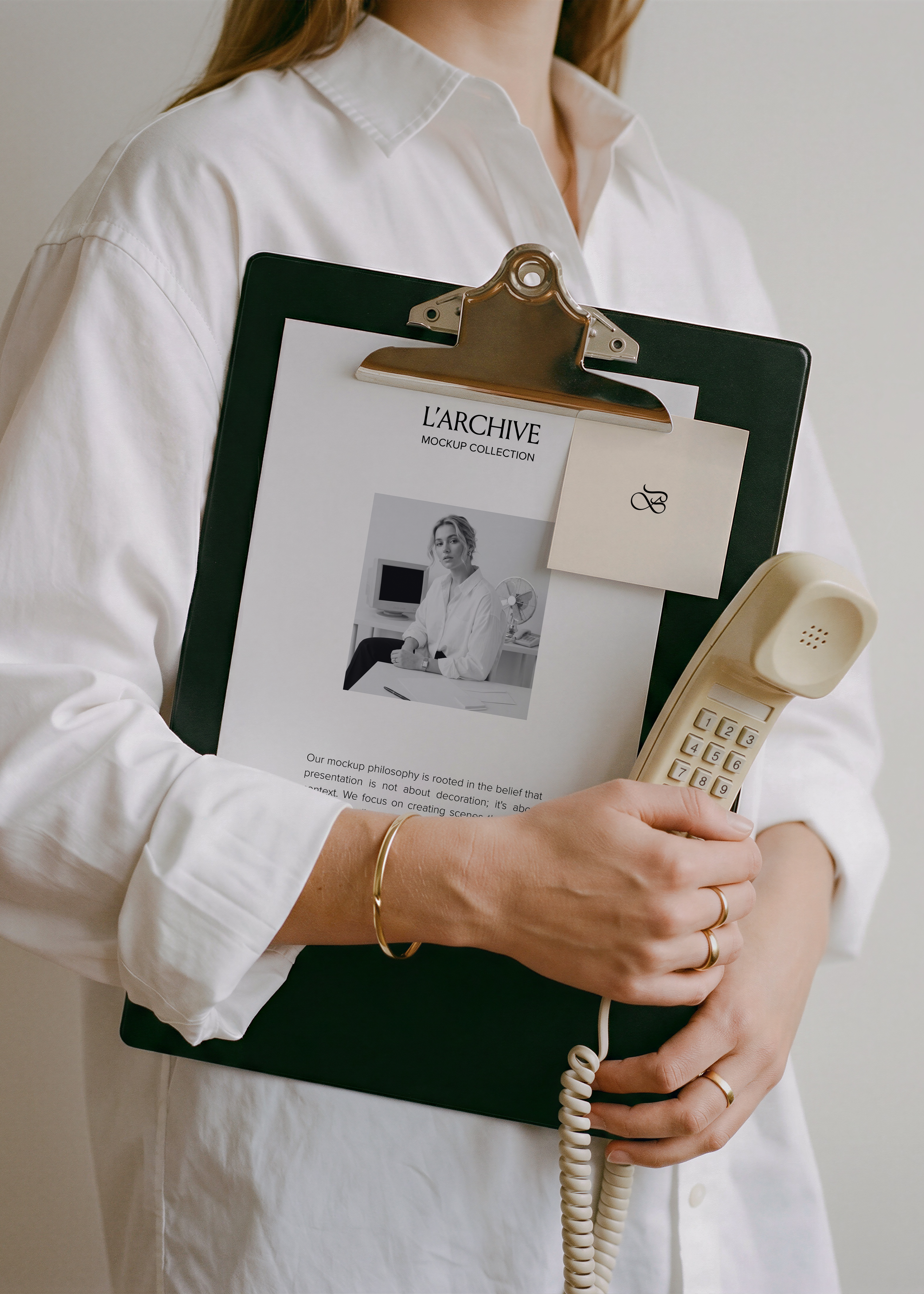 Card stationery mockup with sticky note clipped to dark clipboard, held with cream vintage handset, white shirt sleeve