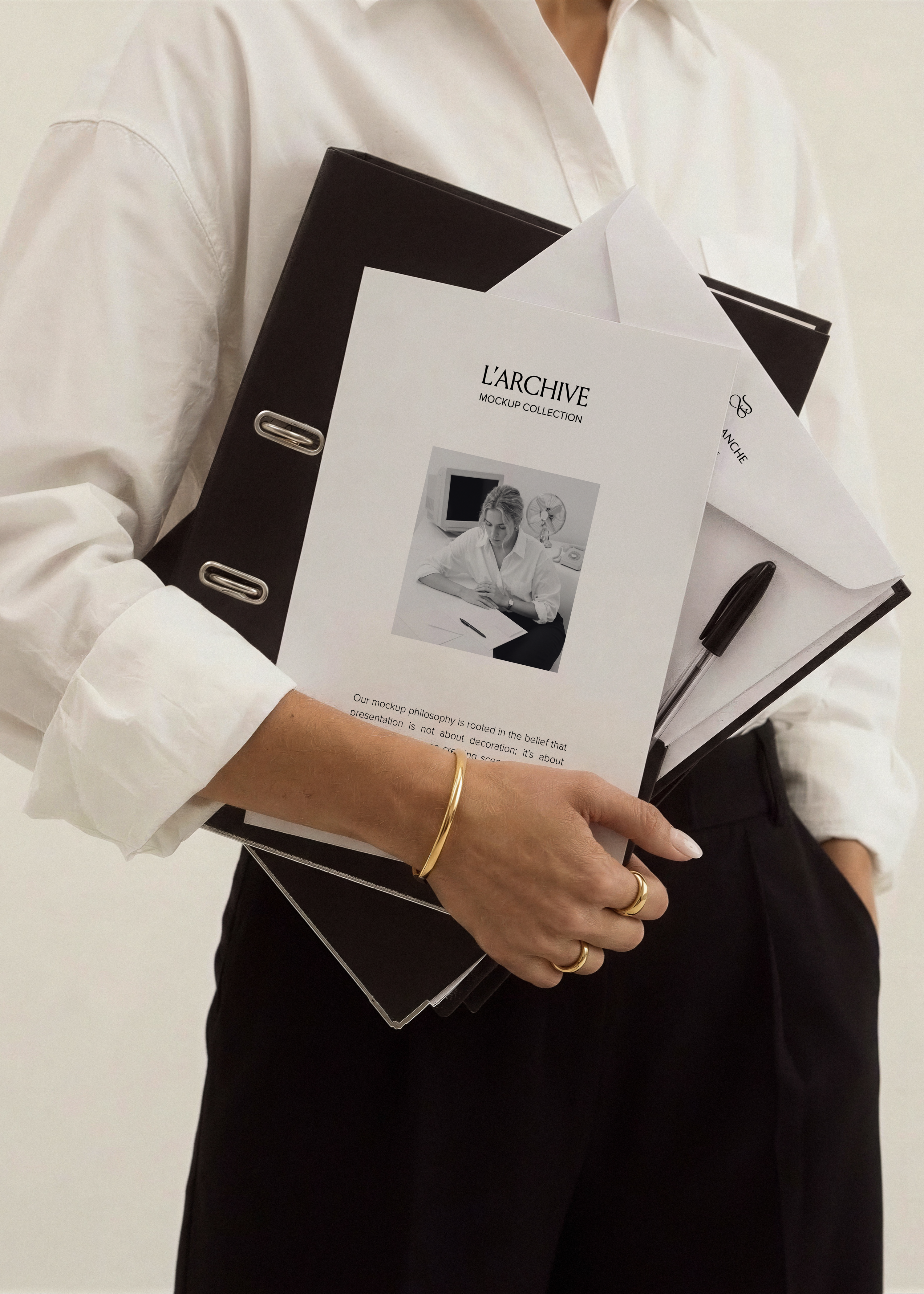 A4 card and envelope mockup held against black trousers with leather binder, white shirt, gold jewellery, office styling