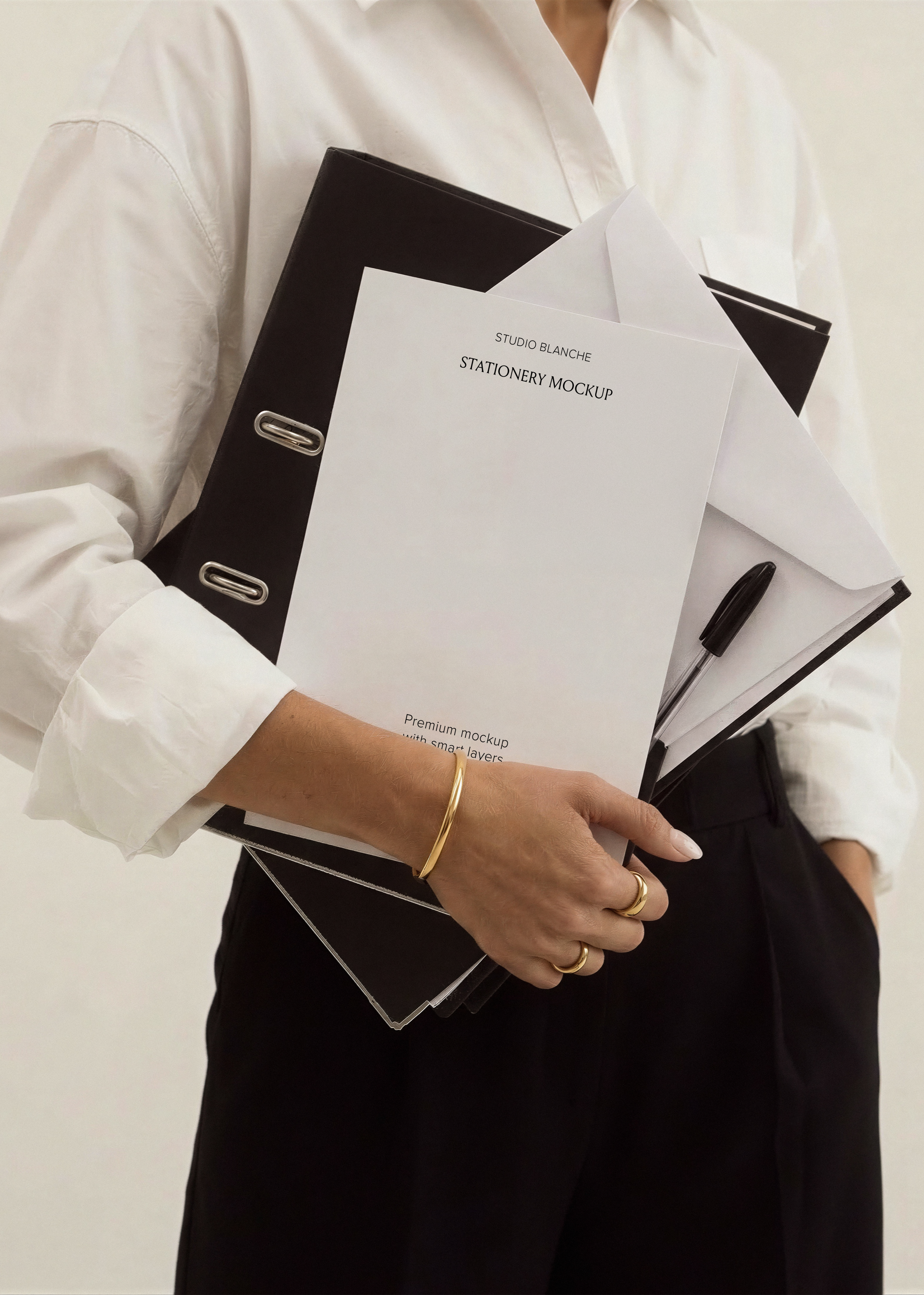 Blank A4 stationery card with white envelope and black pen resting on leather folder, minimal editorial office scene