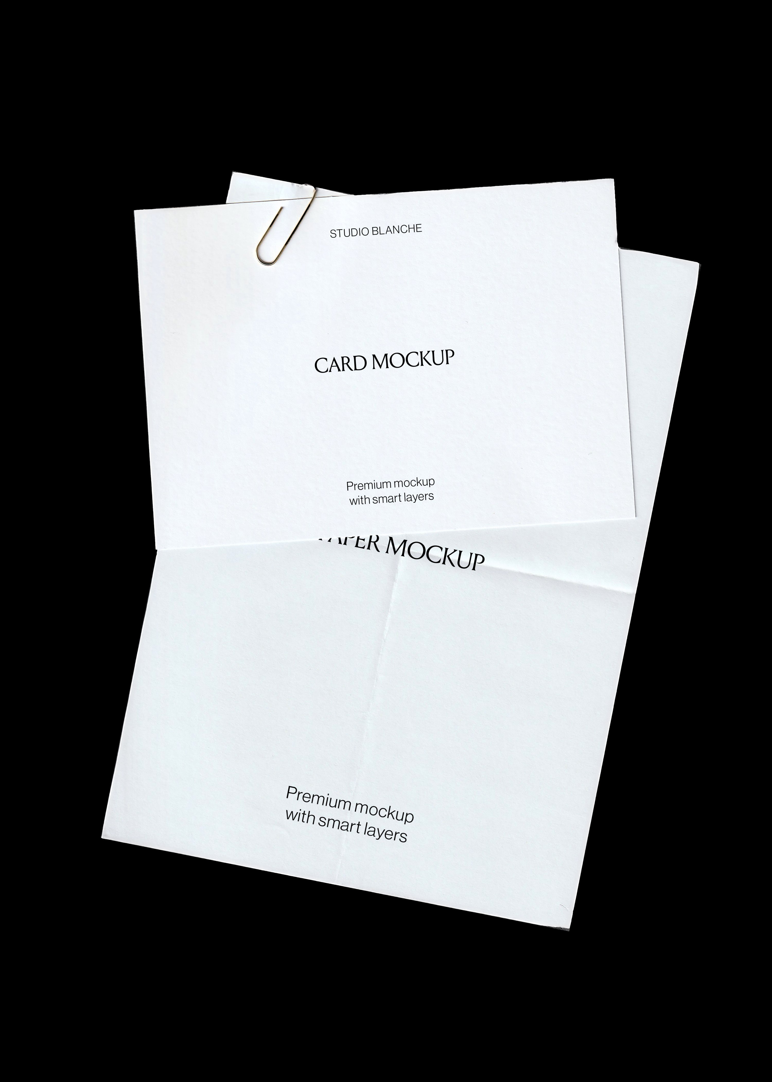 Card and paper mockup on black, textured white card with gold paperclip above a creased folded A4 sheet