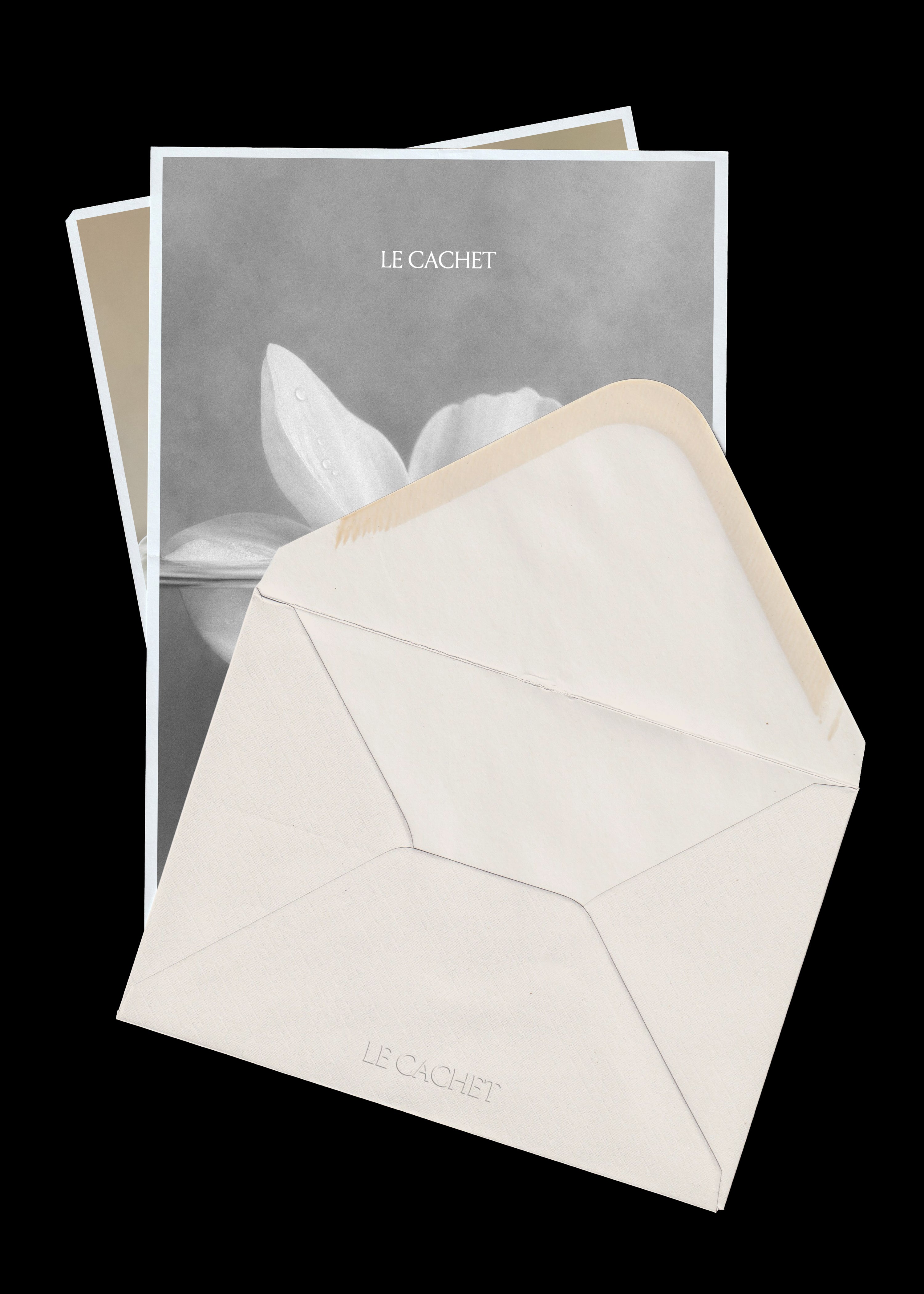 Envelope and paper mockup on black, cream textured envelope with open flap over a grey flower print card