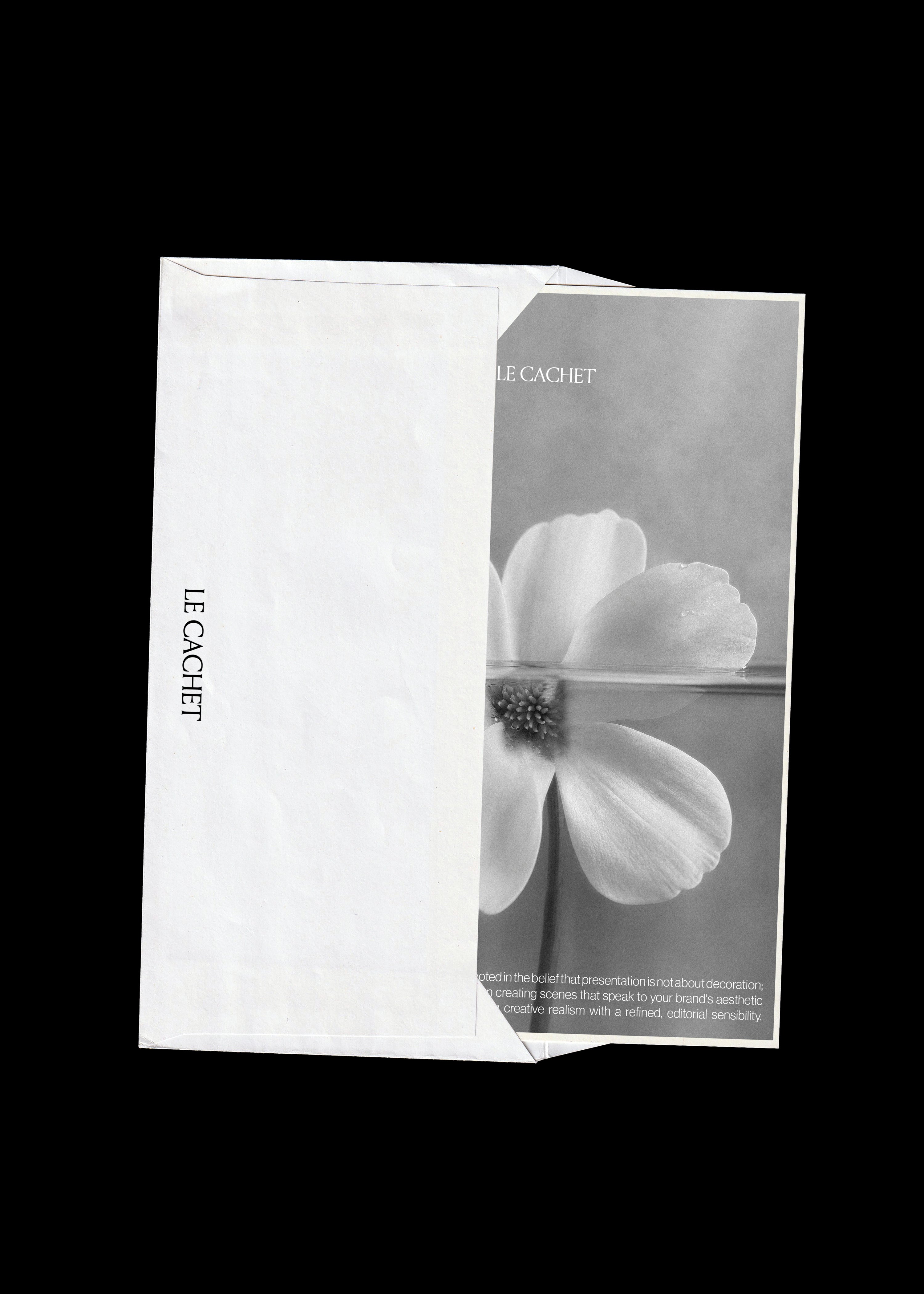 Card and envelope mockup on black, white envelope overlapping a grey flower print card with vertical text
