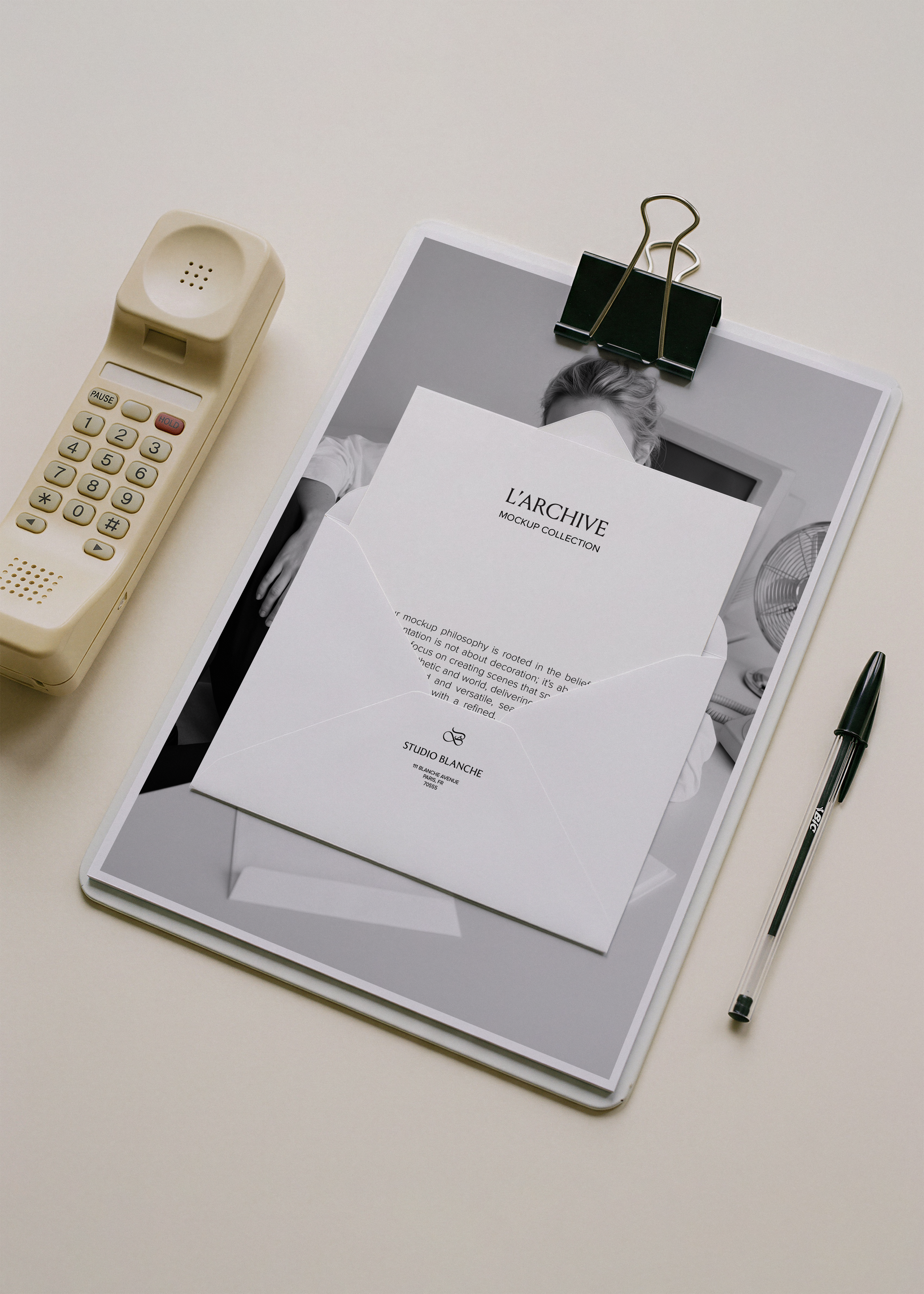 A4 card and open envelope stationery mockup clipped to board with vintage cream handset and black biro, pale desk surface