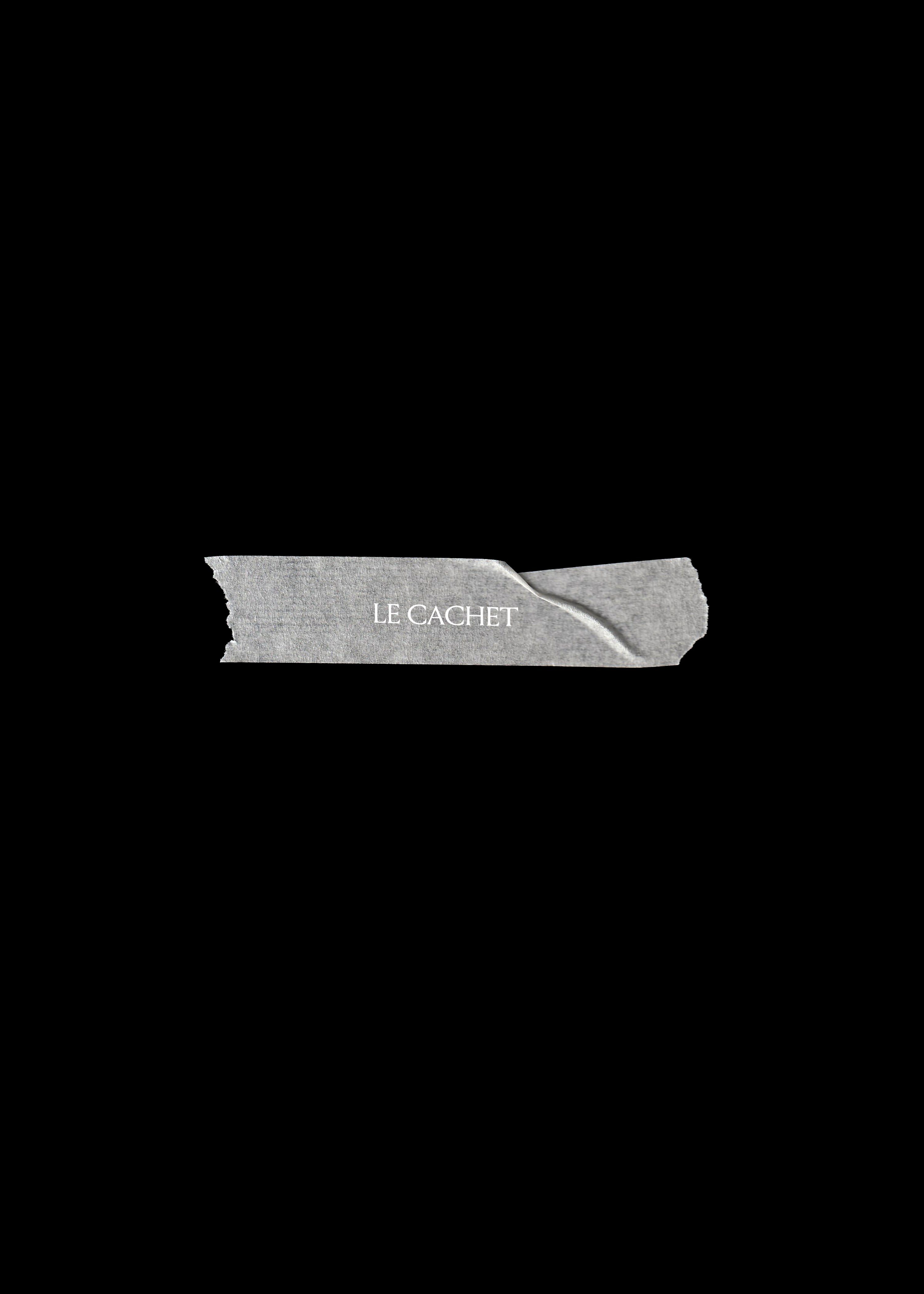 Torn grey paper tape strip mockup on black with a crease at one end and white serif brand name
