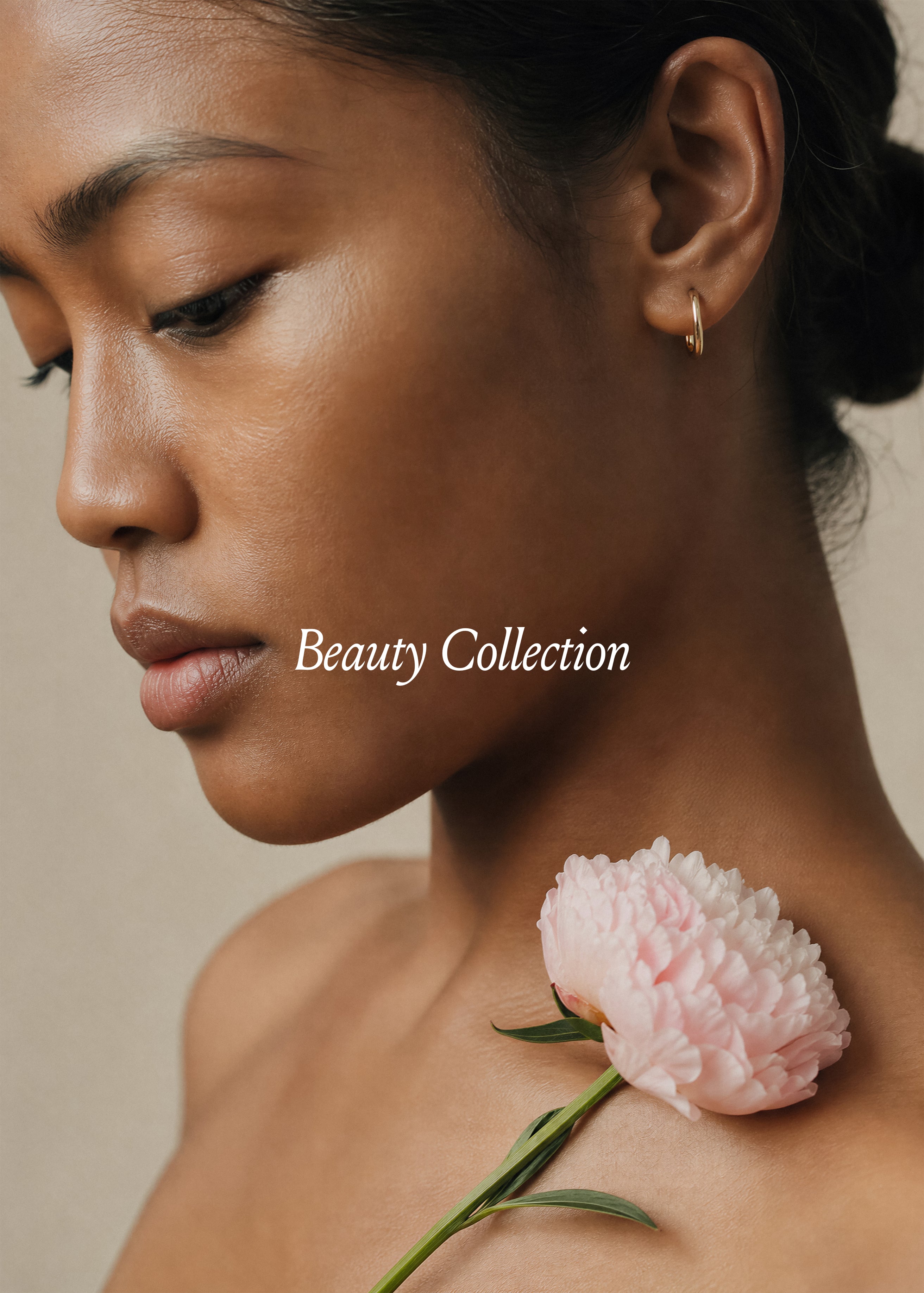 Editorial beauty stock photo of woman in profile with pink peony on shoulder, warm sand background, Beauty Collection 