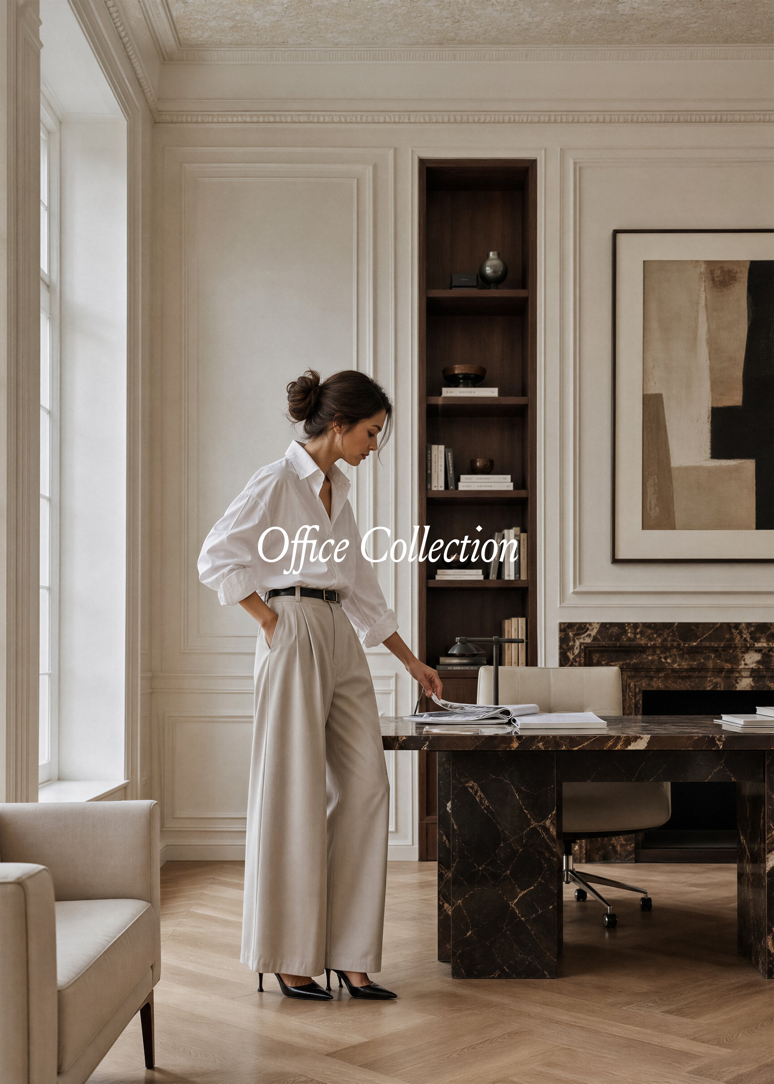 Woman in white shirt and stone wide-leg trousers at dark marble desk in cream plaster-moulded office, Office Collection stock