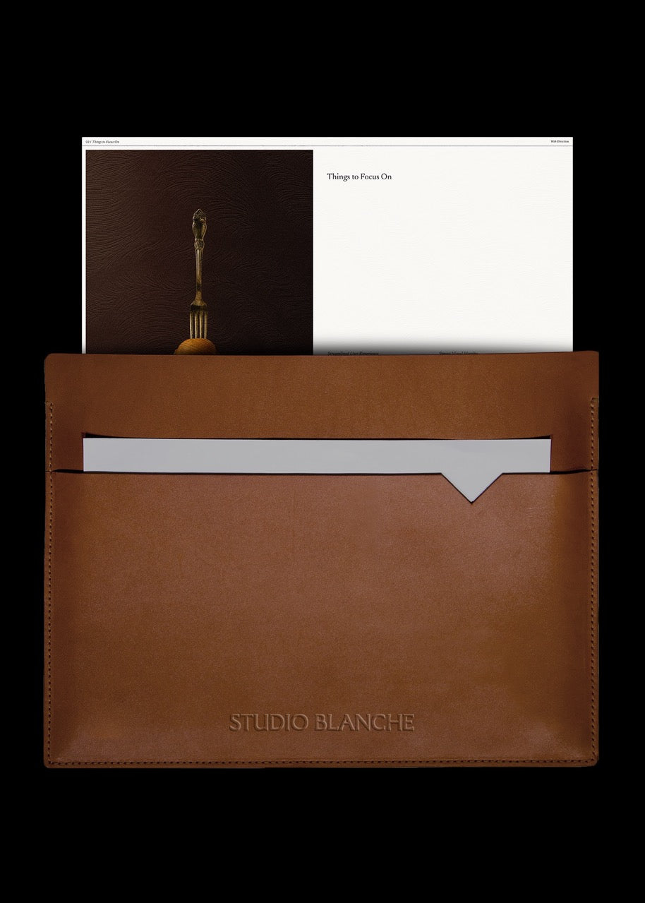 Brown leather pouch with a white card and a black background
