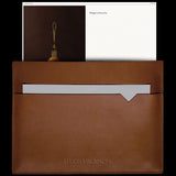Brown leather pouch with a white card and a black background