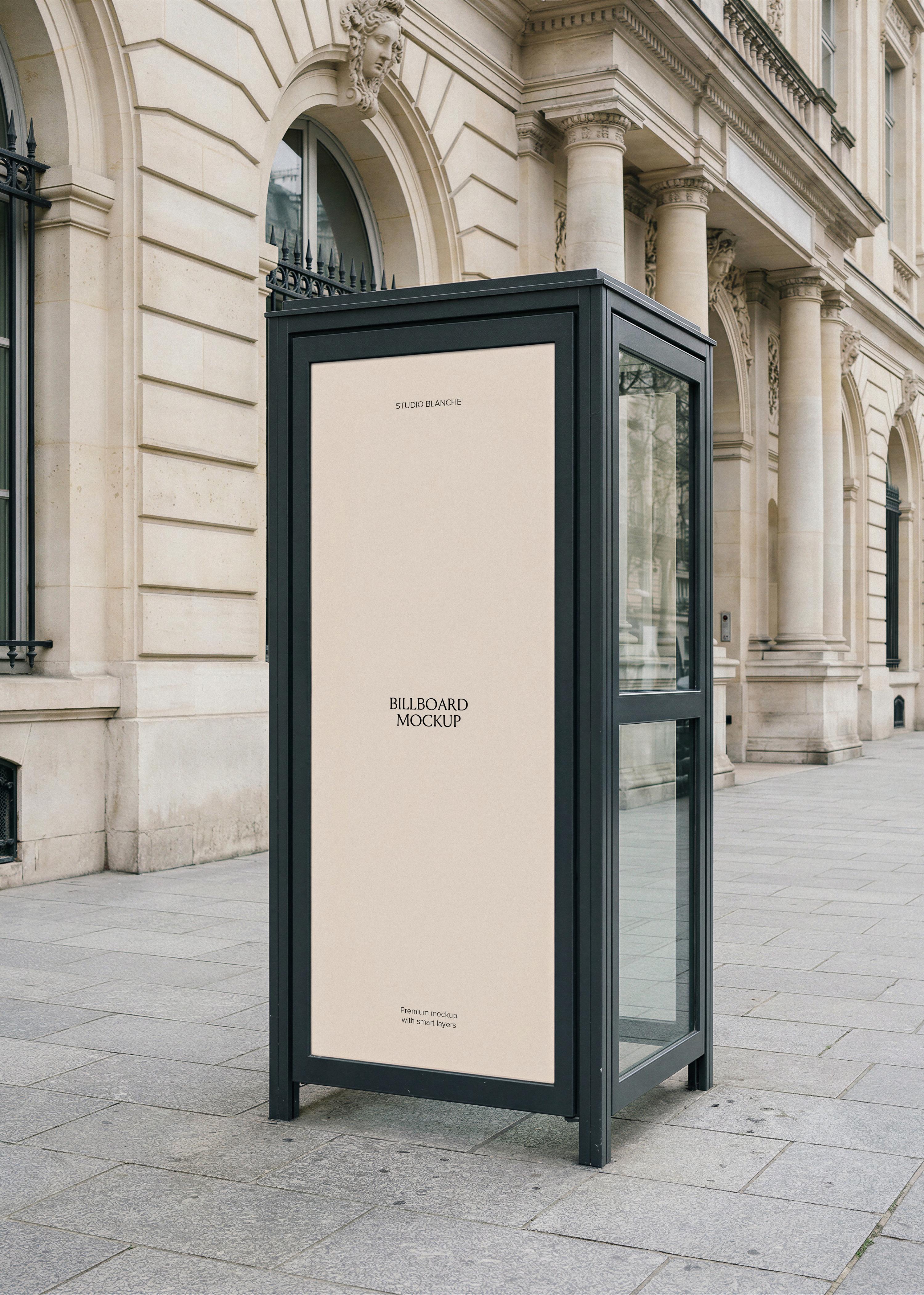 Blank telephone booth mockup with black steel frame on a Parisian street, empty panel with Studio Blanche label