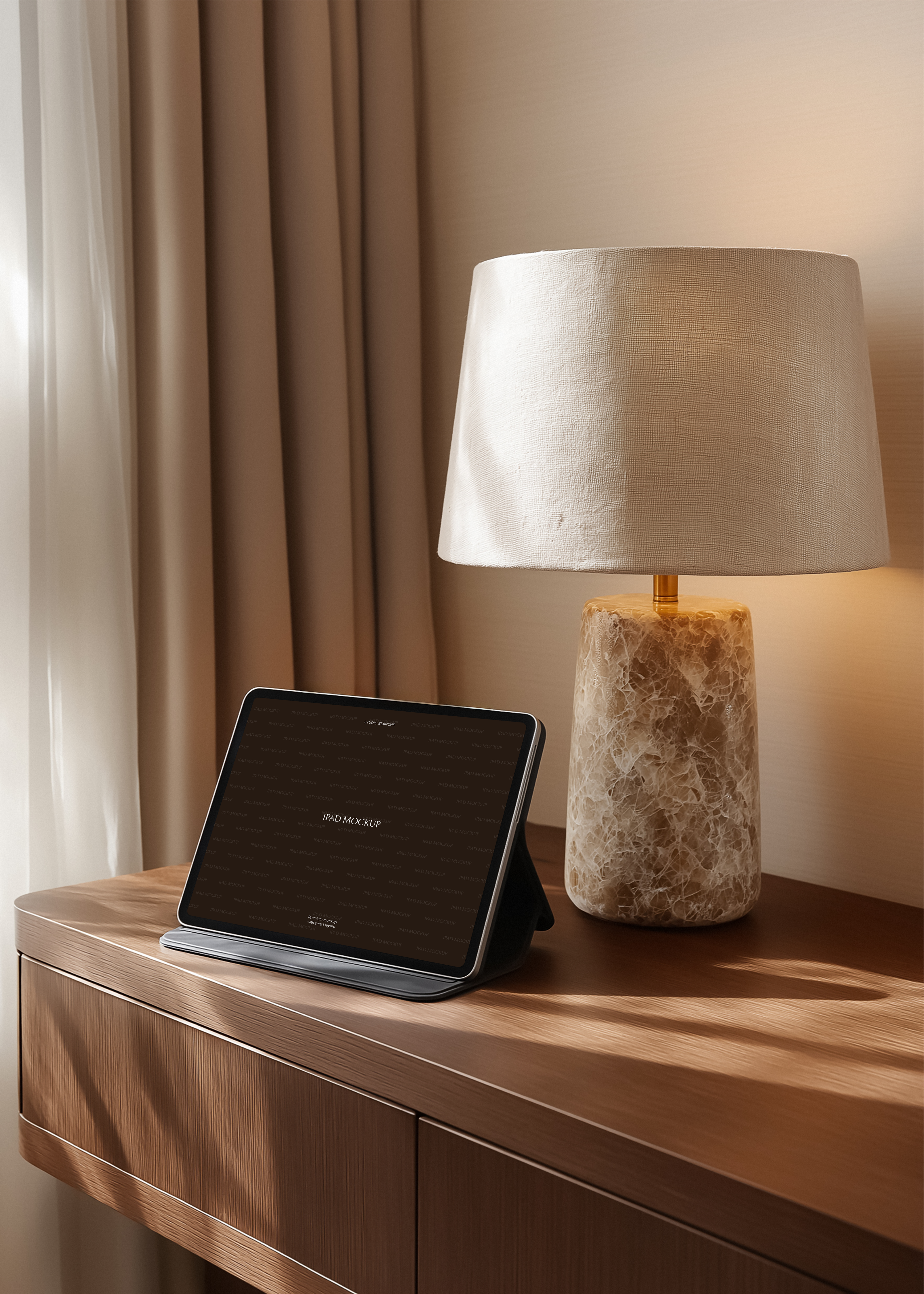 iPad mockup in black case on oak sideboard beside stone and brass table lamp, warm interior editorial scene