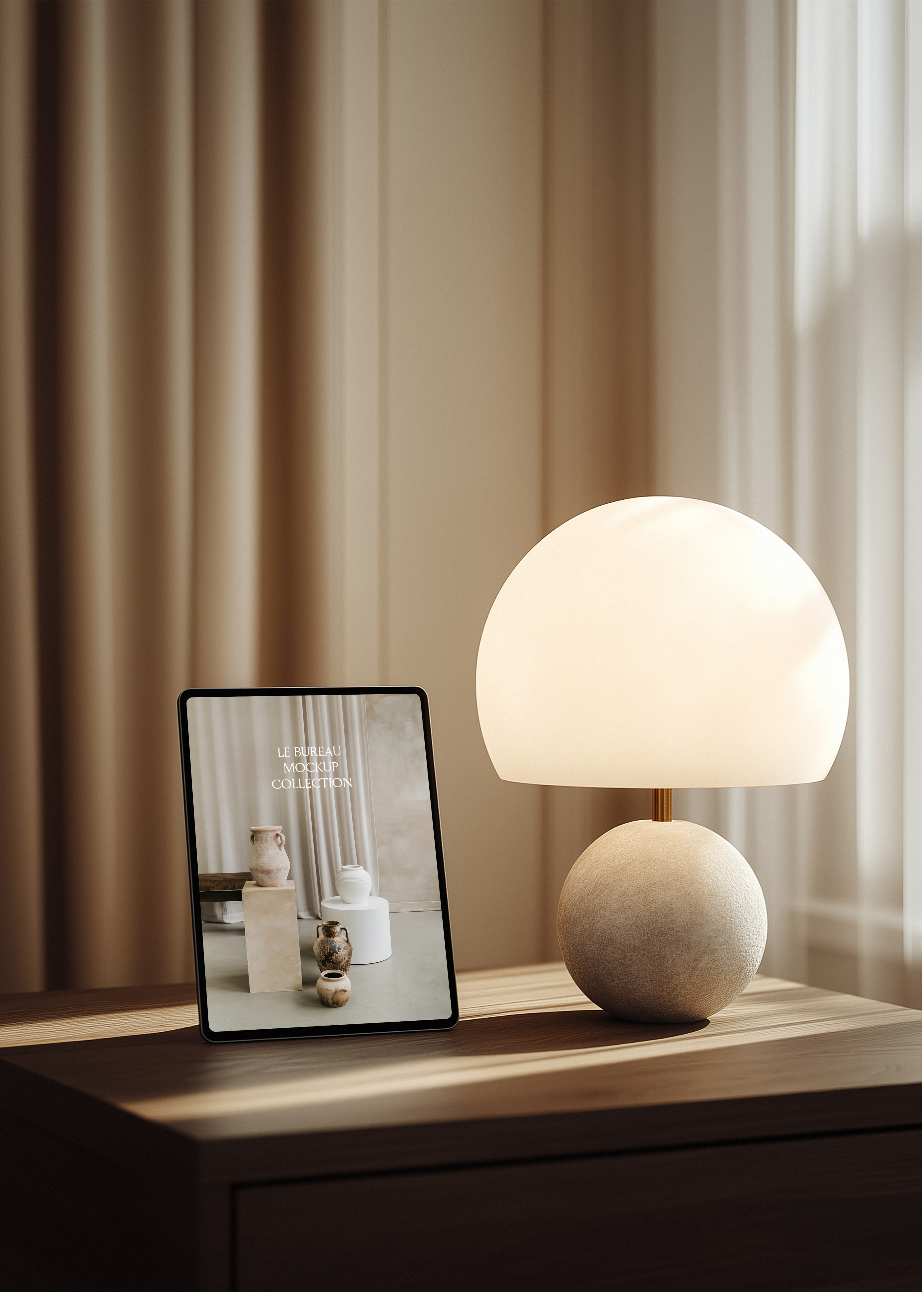 iPad mockup displaying Le Bureau collection editorial on oak desk, sculptural globe lamp and linen curtain backdrop