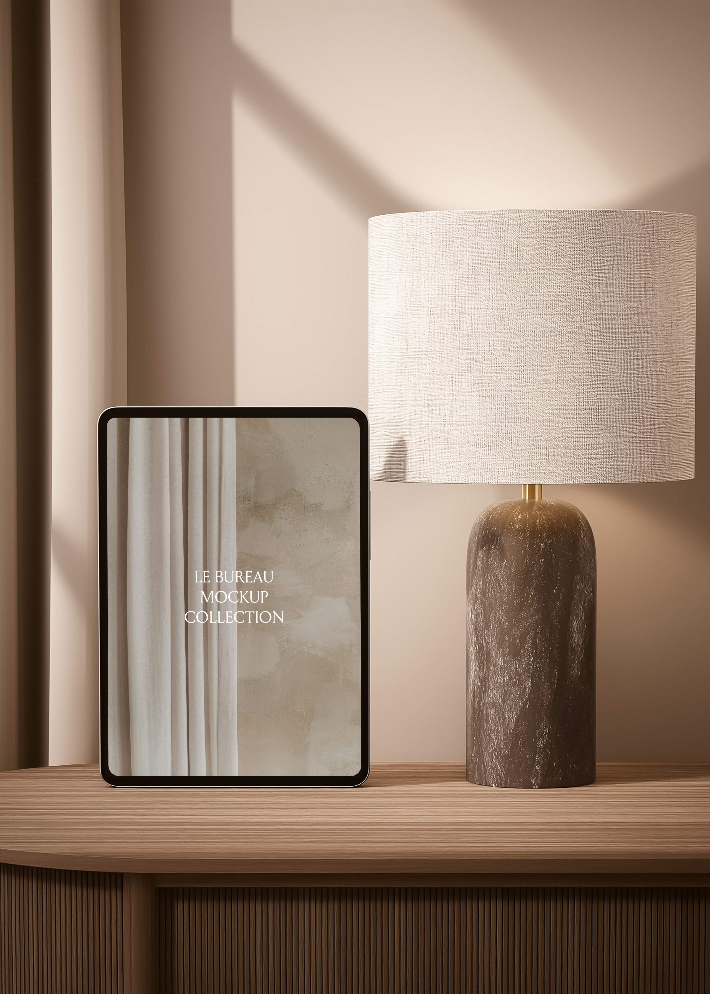 iPad mockup displaying Le Bureau editorial on ribbed console, dappled wall light and linen drum lampshade backdrop