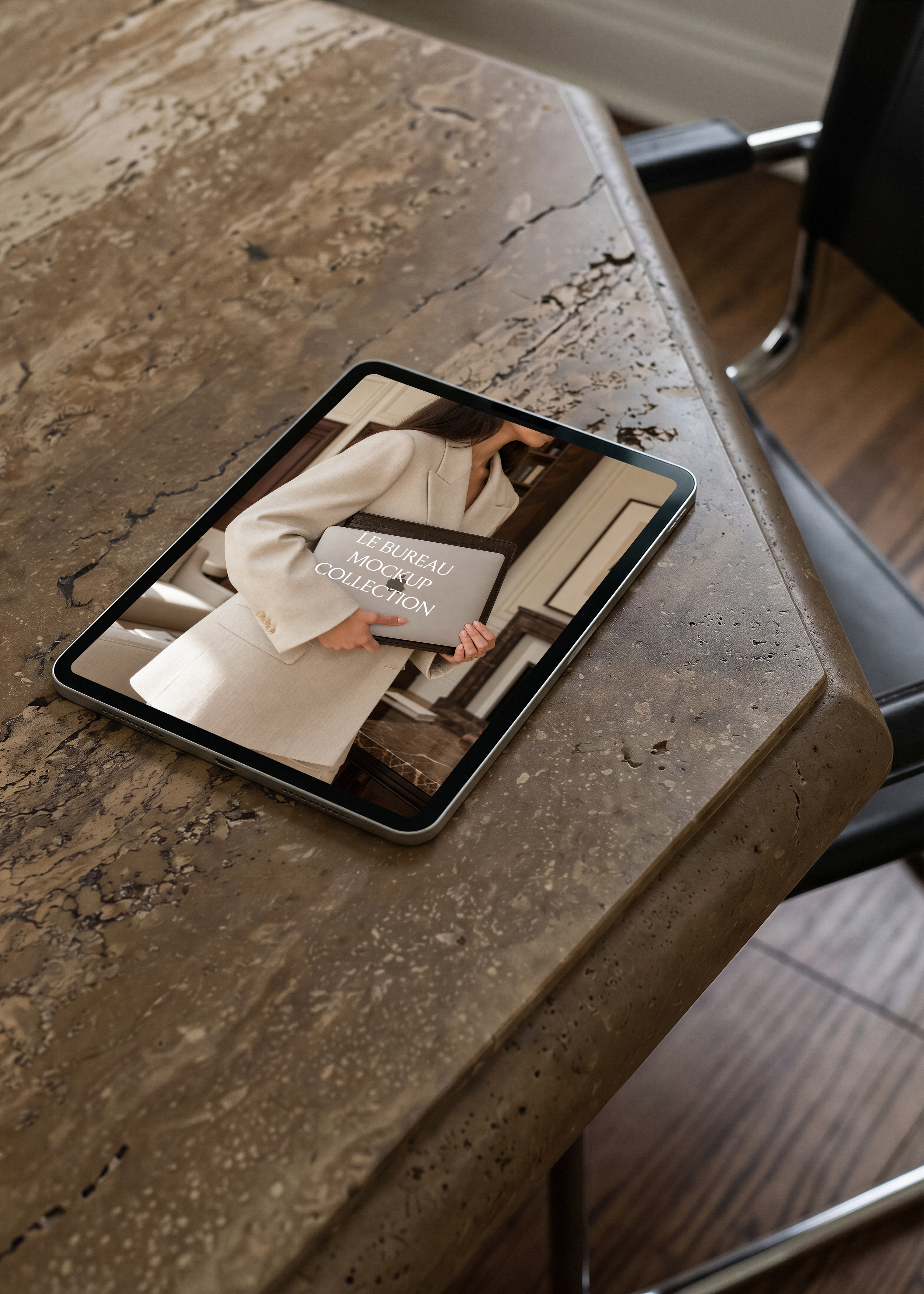 iPad mockup on travertine surface displaying Le Bureau editorial image, moody warm architectural scene
