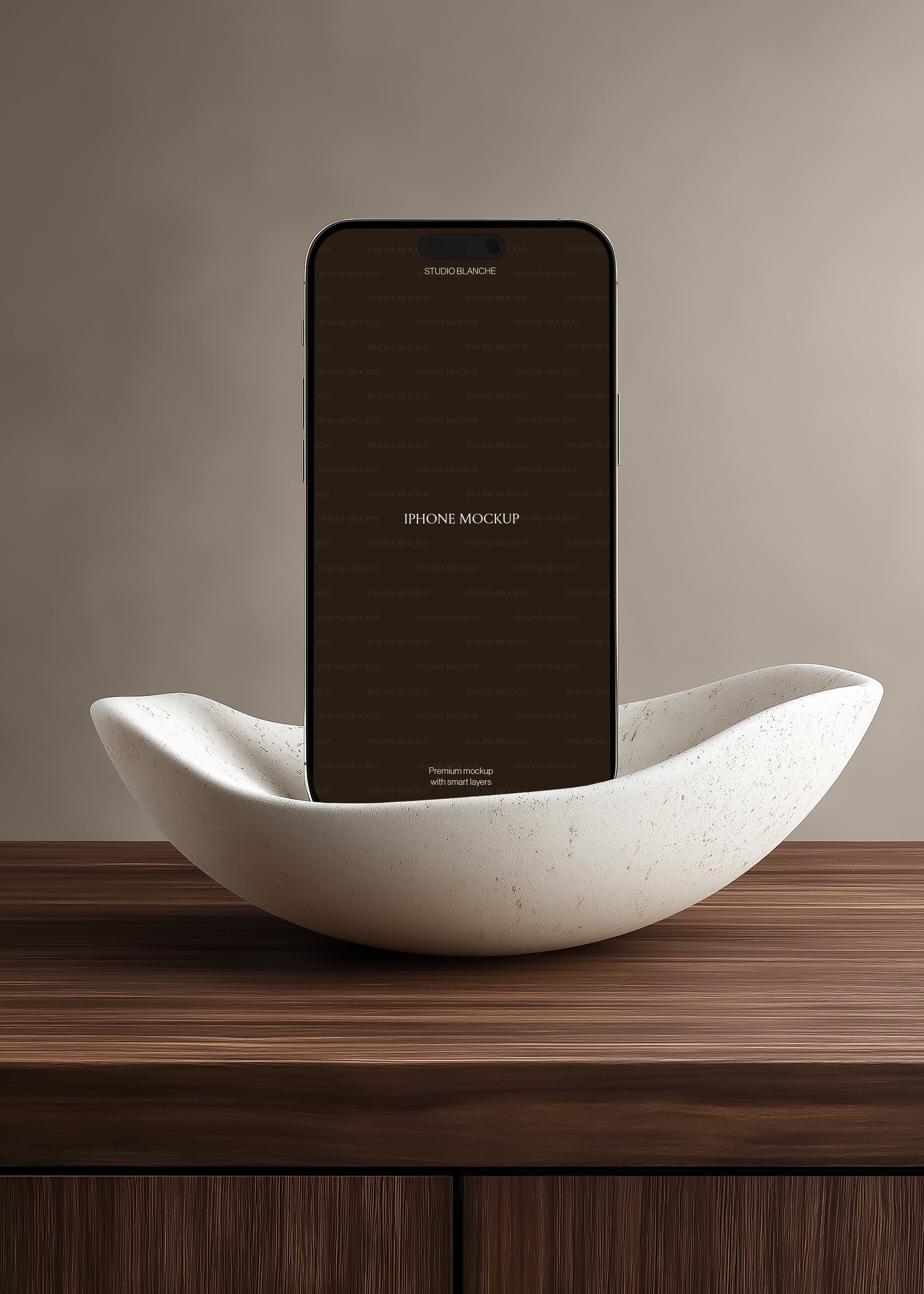 iPhone mockup cradled in travertine-effect sculptural bowl on dark striped oak surface, soft greige wall backdrop