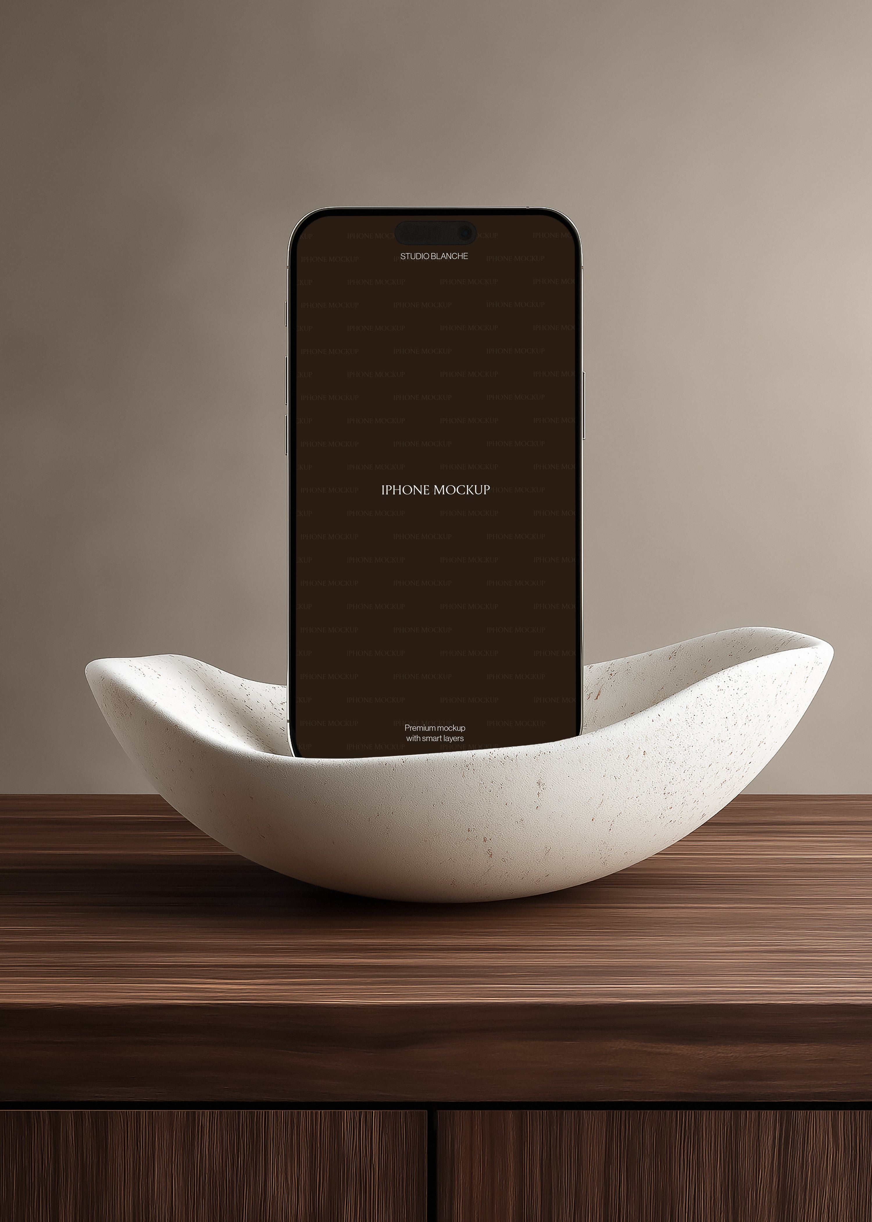 iPhone mockup cradled in travertine-effect sculptural bowl on dark striped oak surface, soft greige wall backdrop
