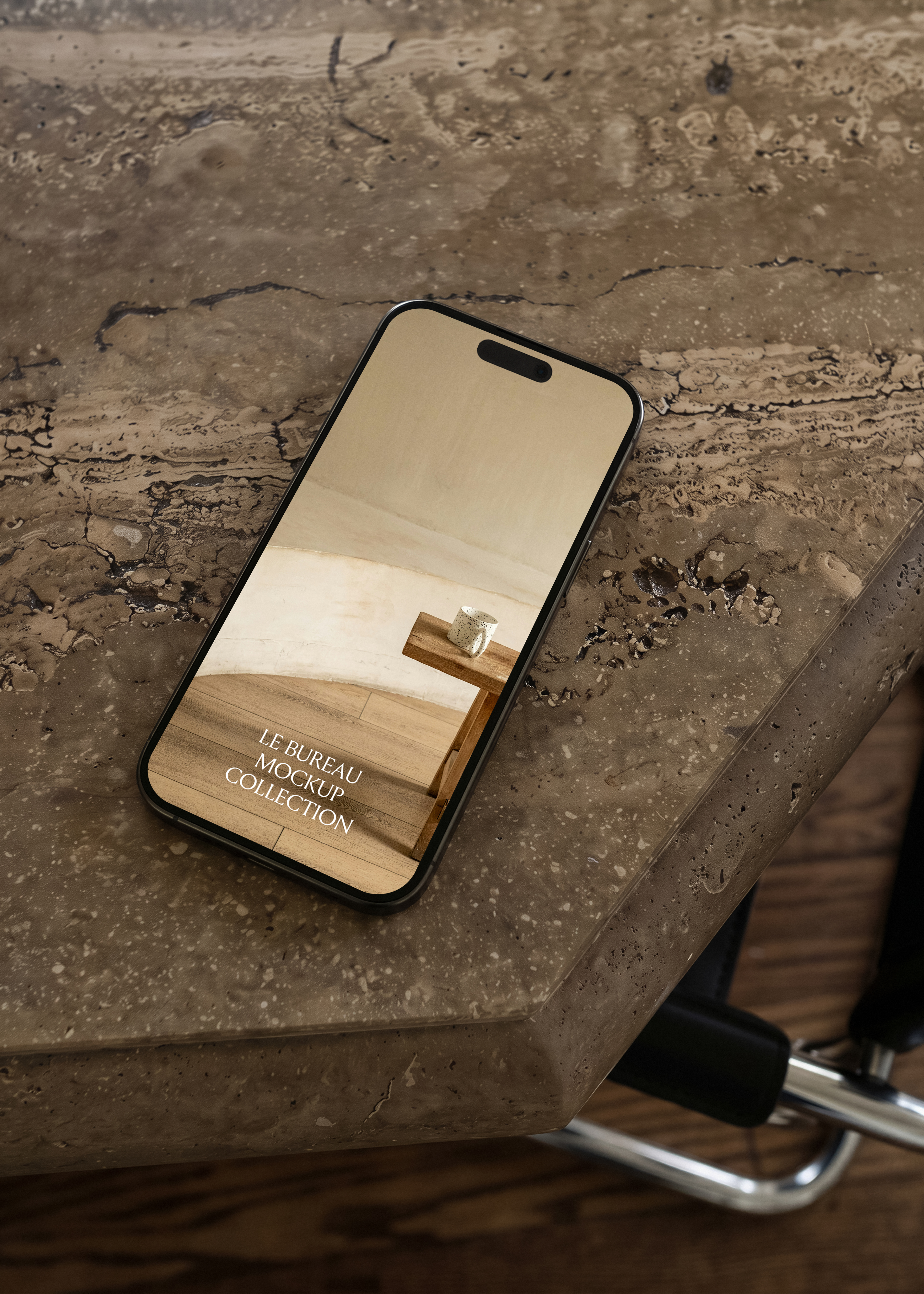 iPhone mockup on travertine surface displaying Le Bureau editorial image, moody warm office scene