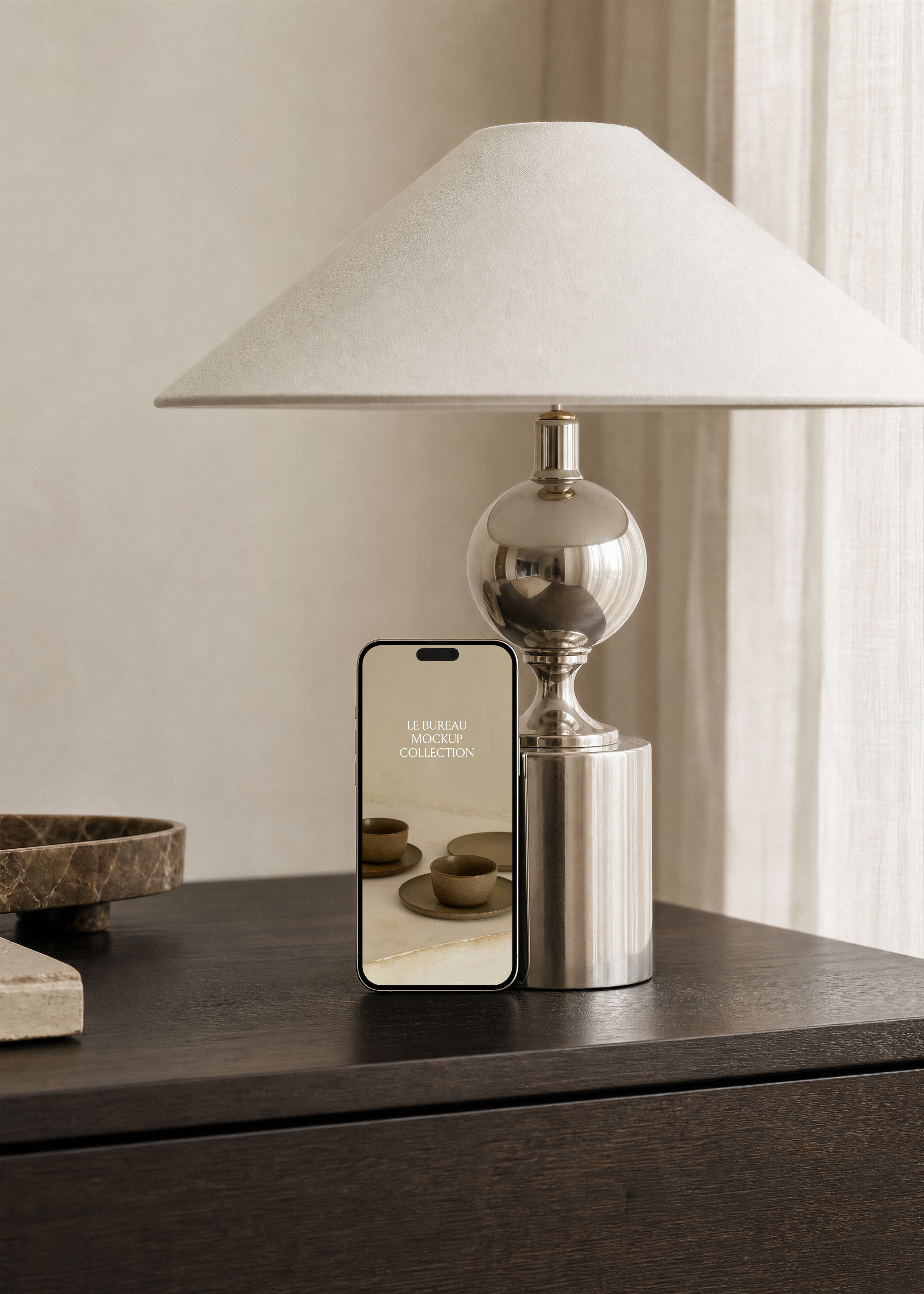Upright iPhone mockup with ceramic cups photo on screen under wide cream lampshade, sheer linen curtain at right