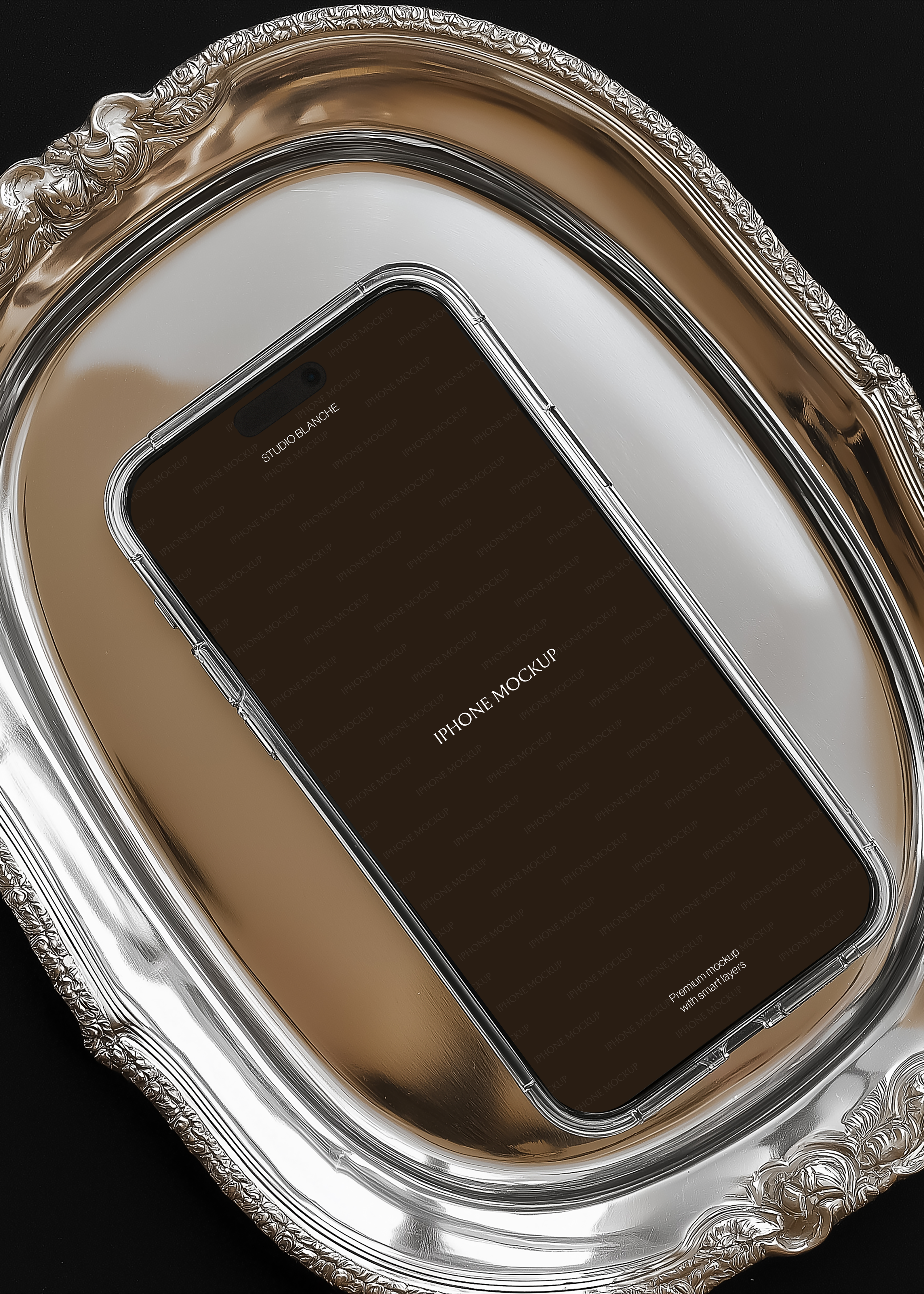 Empty iPhone mockup on antique silver platter, overhead angle, warm gold reflection visible inside tray, dark editorial background