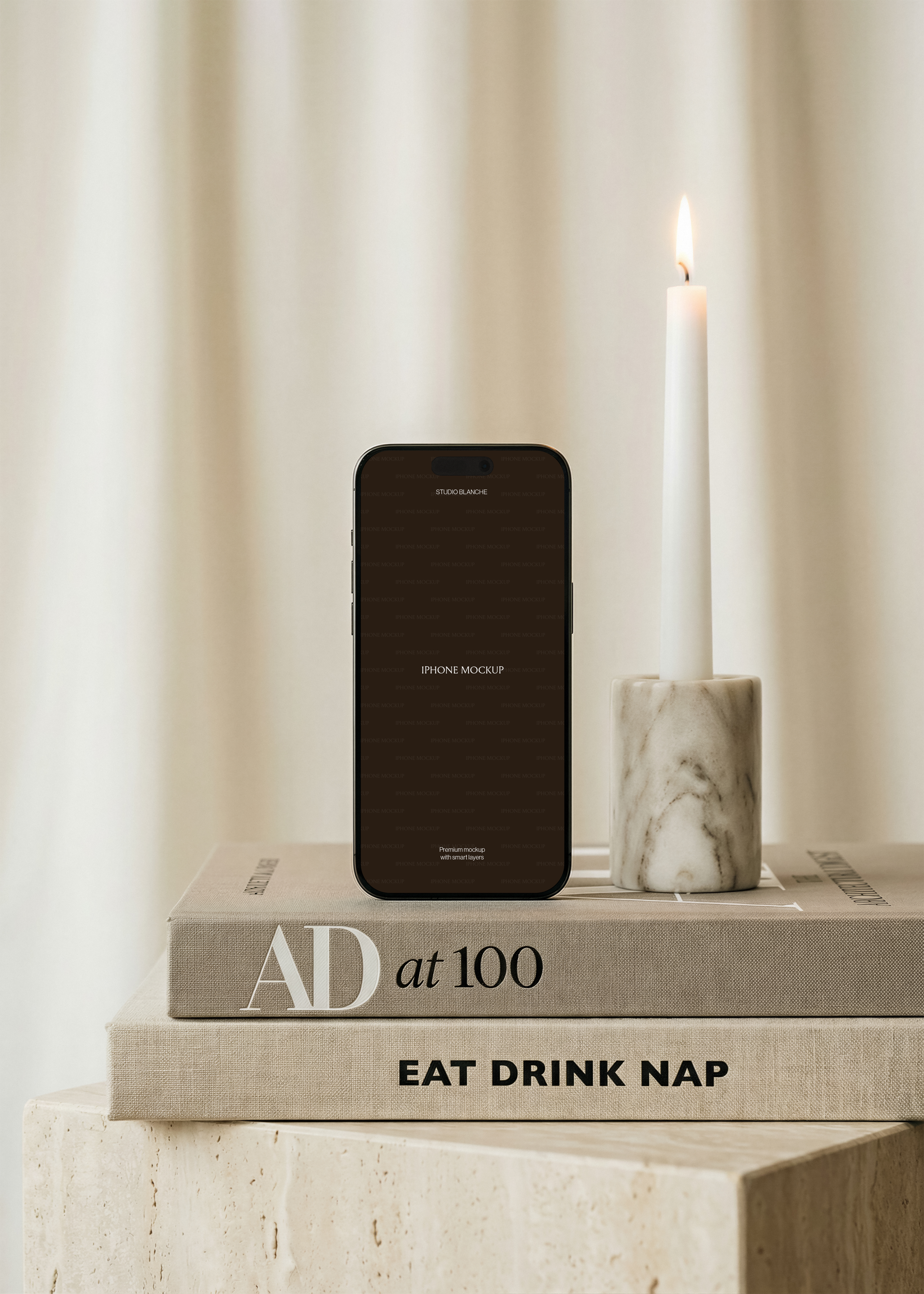 iPhone mockup detail with a dark portrait screen beside a white taper candle in a grey veined marble holder, cream curtain