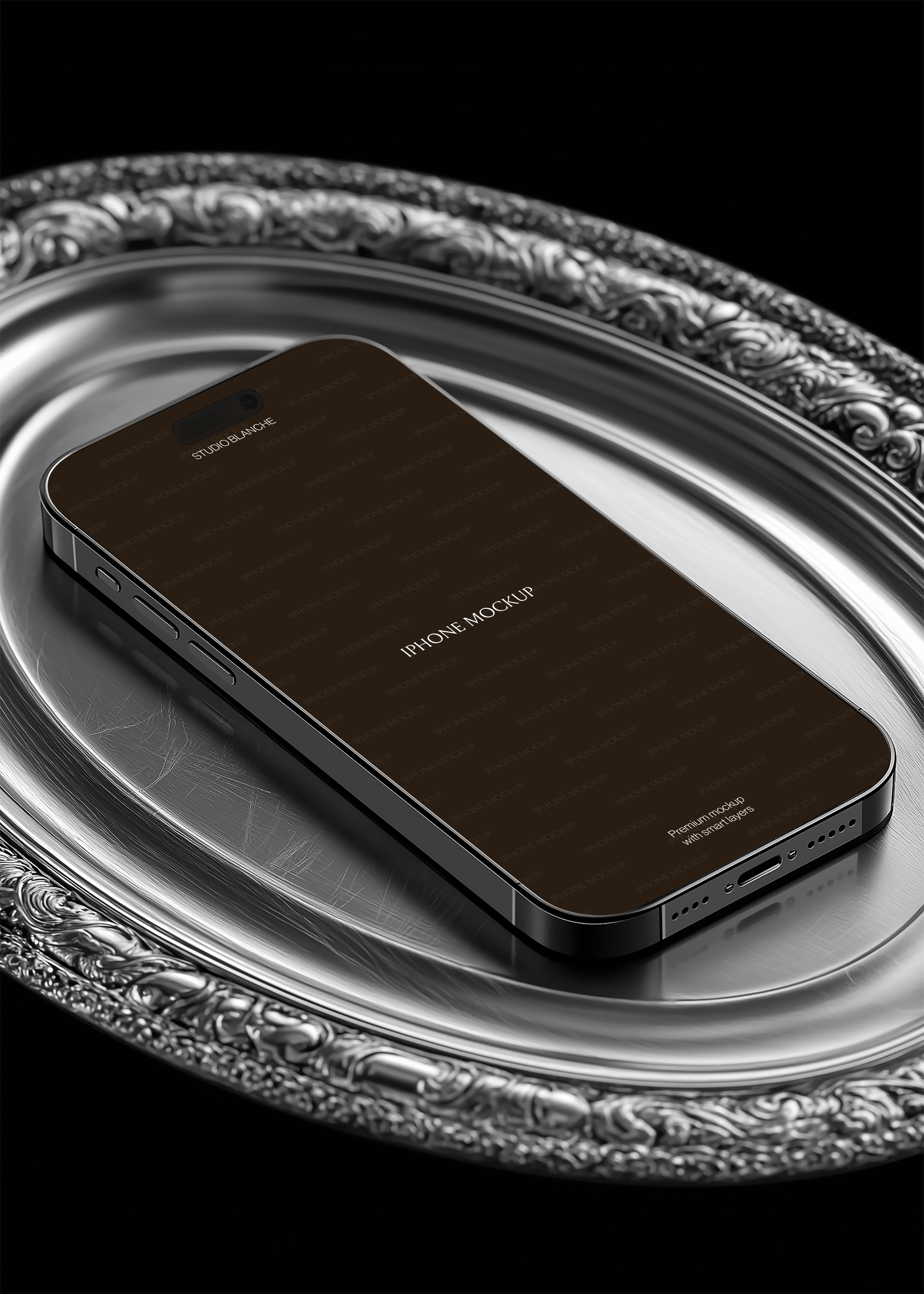 Empty iPhone mockup on engraved silver tray, low-angle view showing device depth, baroque border detail, black background
