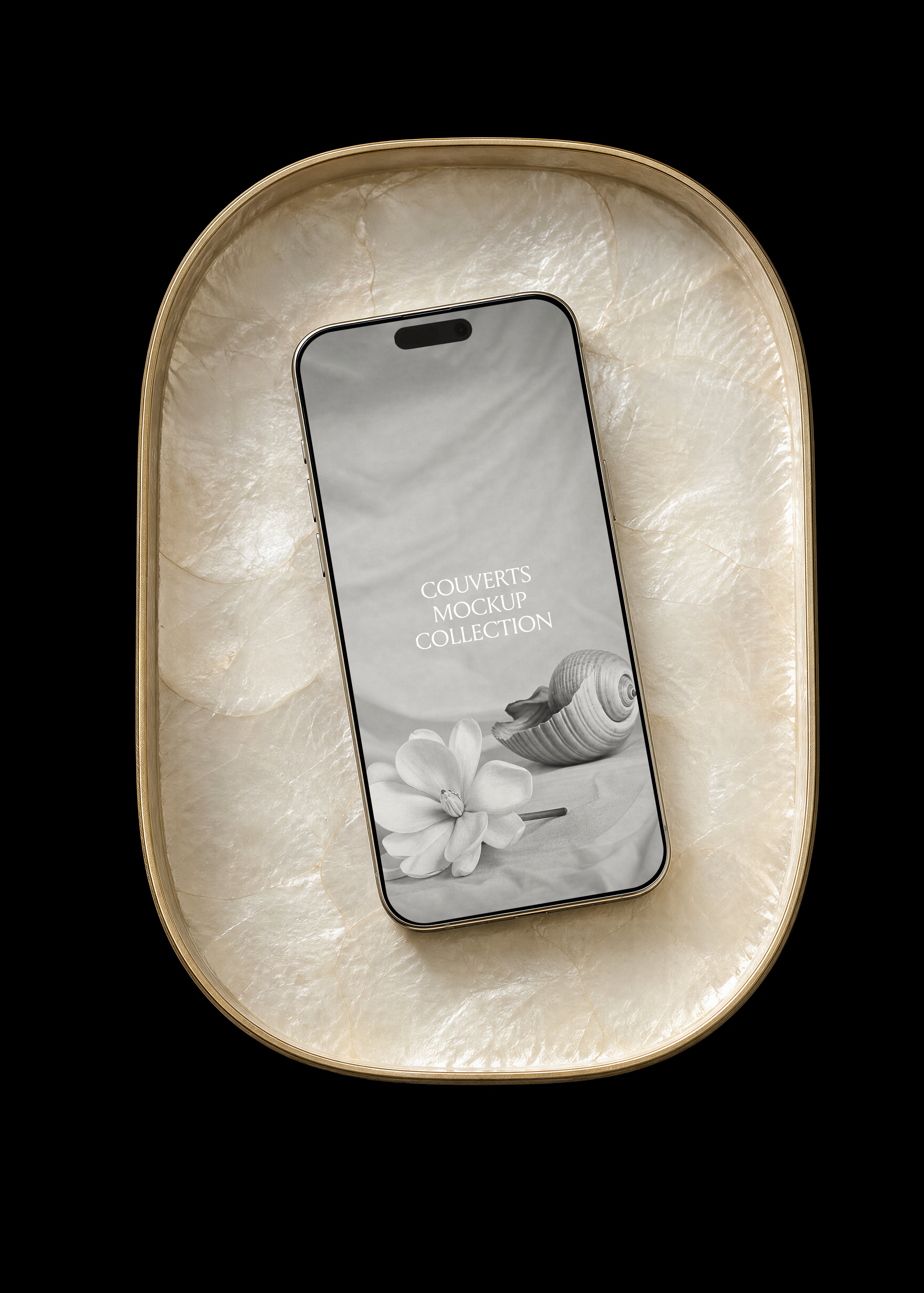 Gold iPhone mockup with botanical screen design resting in a gold-rimmed oval capiz shell tray on a black backdrop