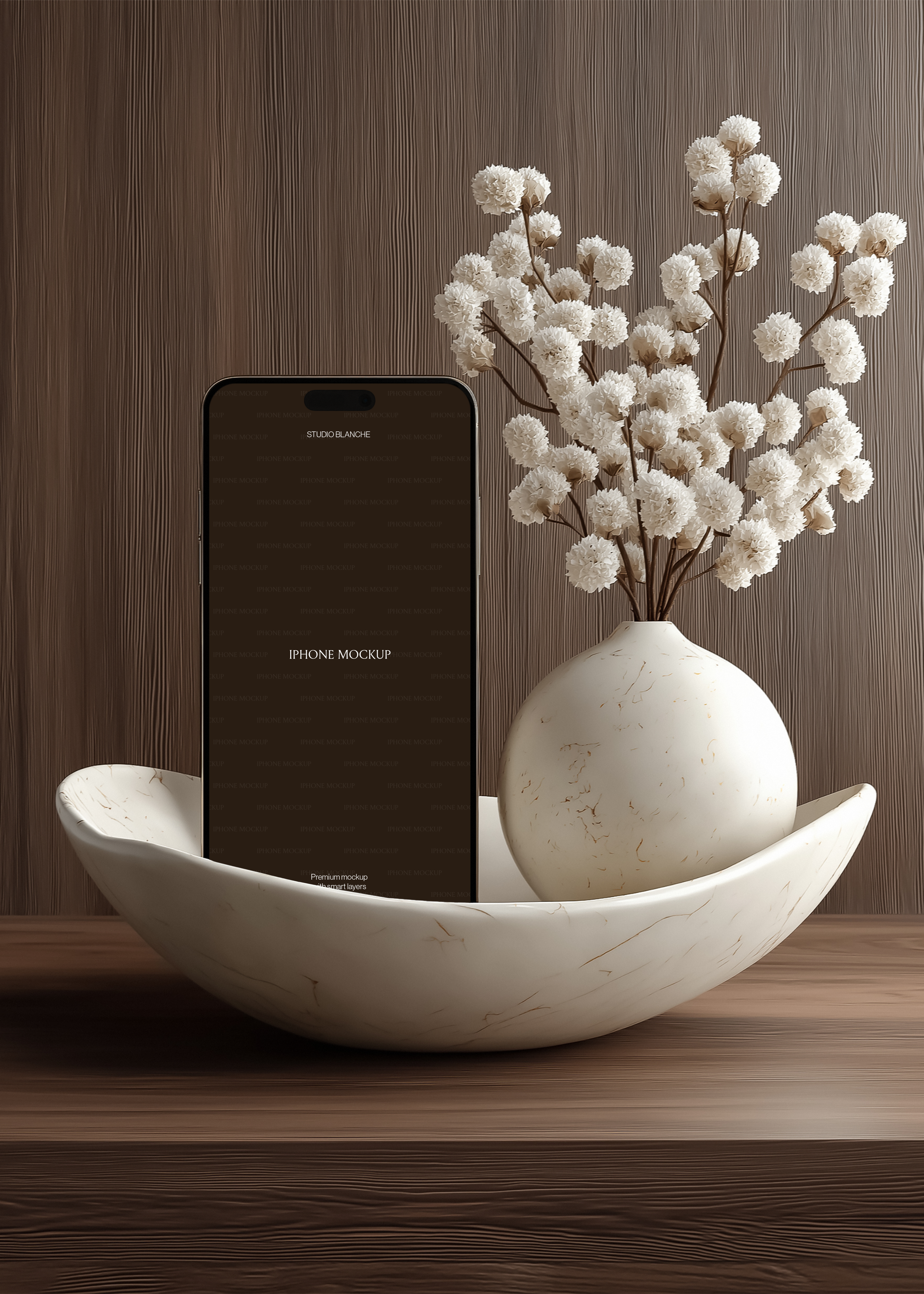 iPhone mockup upright in veined marble bowl beside matching globe vase with dried white blooms, dark wood-grain wall backdrop